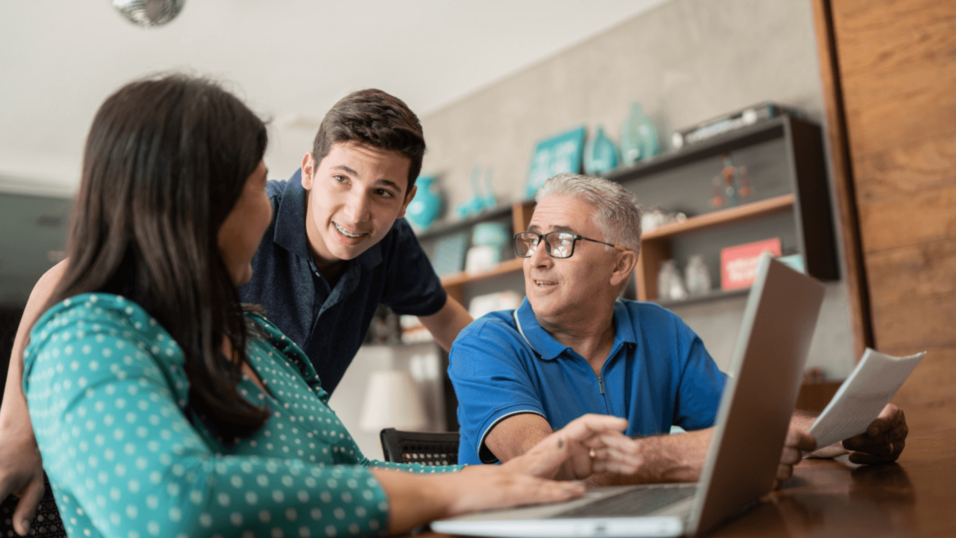 Parent and student reviewing college application budget and research program options at a desk