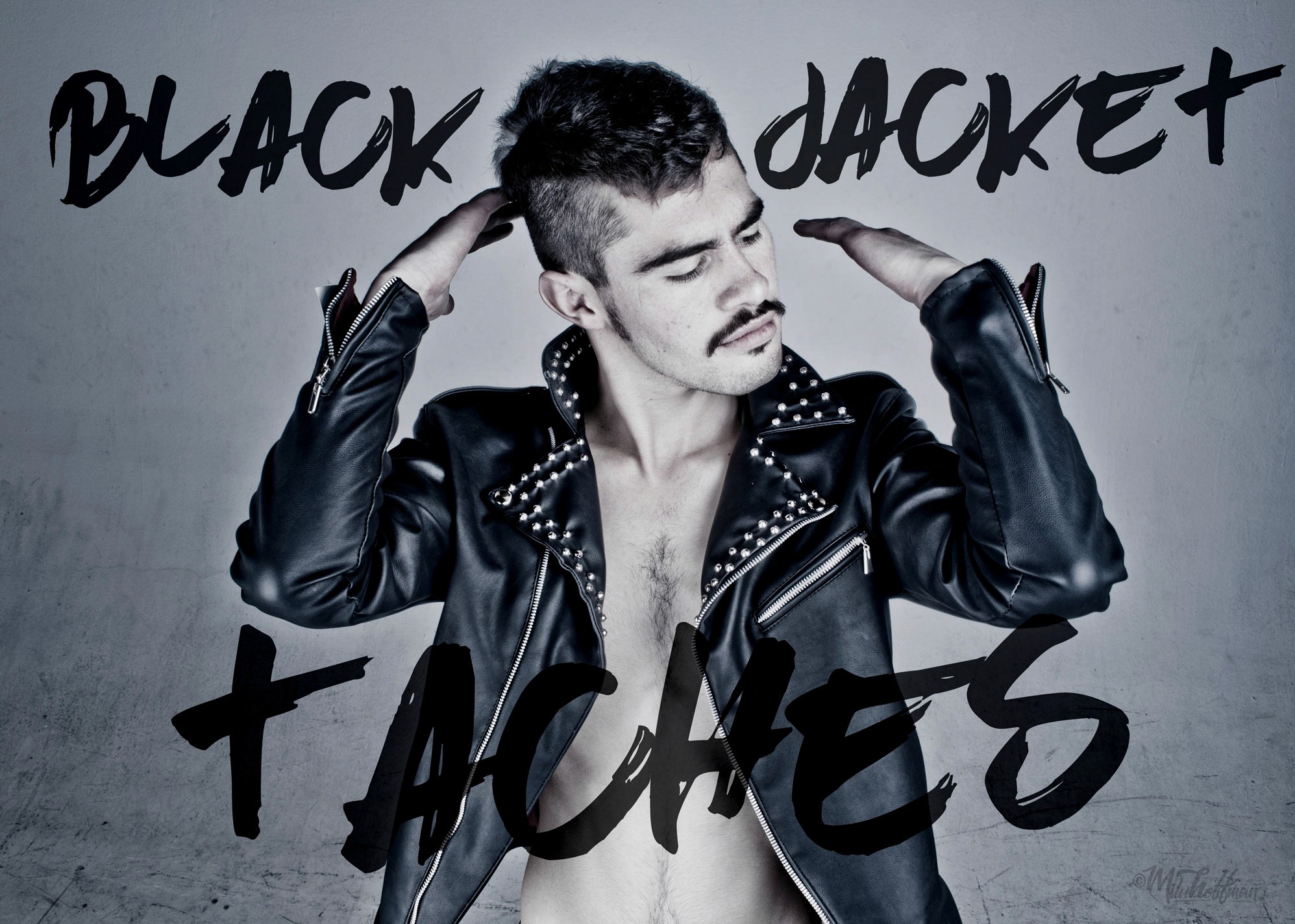 Wide shot of a man with his hands behind his head, wearing an open black studded leather jacket. Large, stylized "BLACK JACKET + TACHES" text is layered over the image.