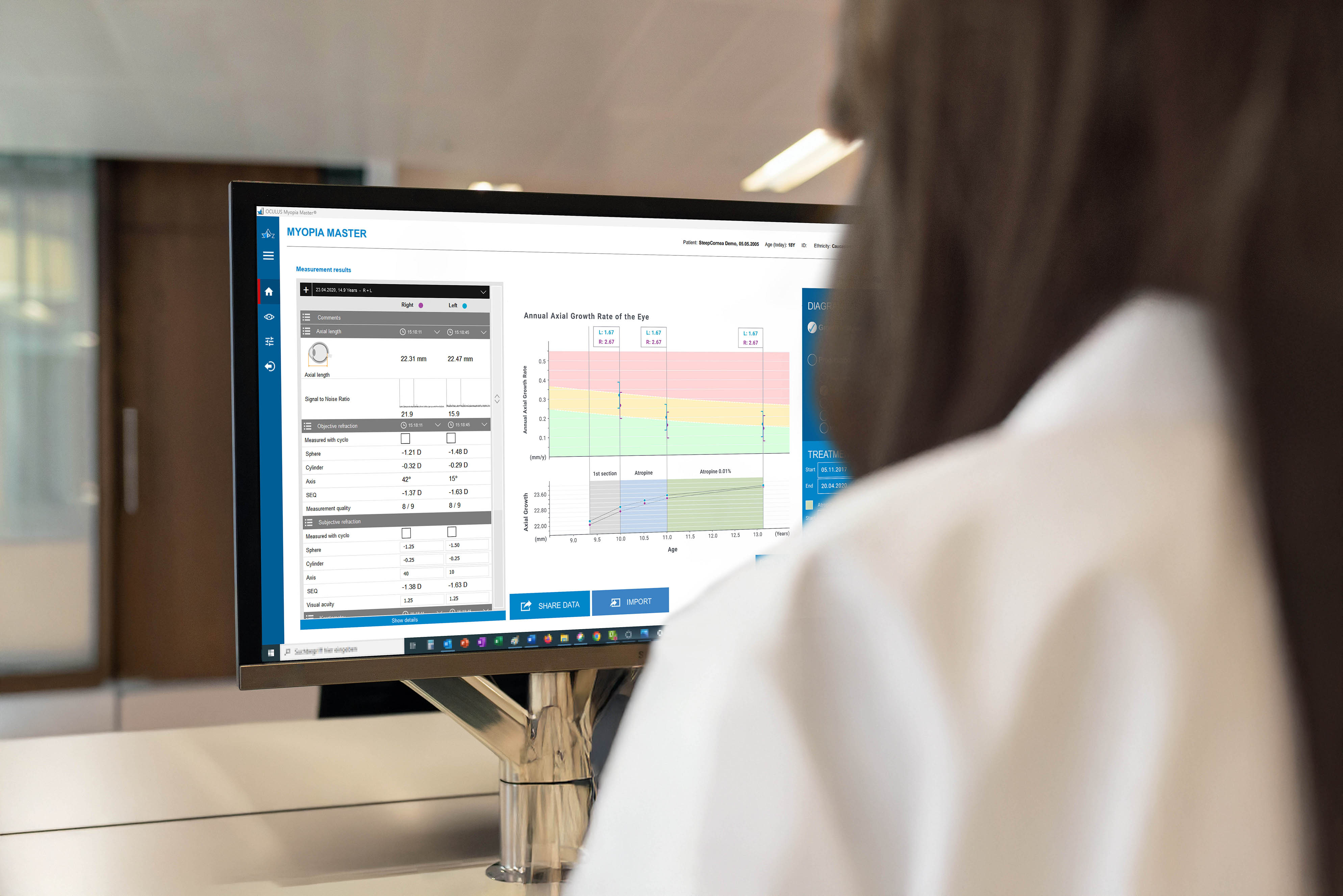View over a doctor’s shoulder as she analyzes examination charts on a computer in a medical office.