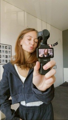 Creator filming a selfie video with a handheld camera