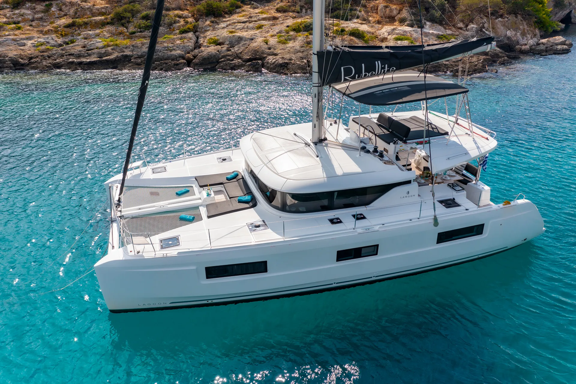 White Rock 36 speedboat with captain at helm cruising calm blue waters near Paros coastline with hills in background.