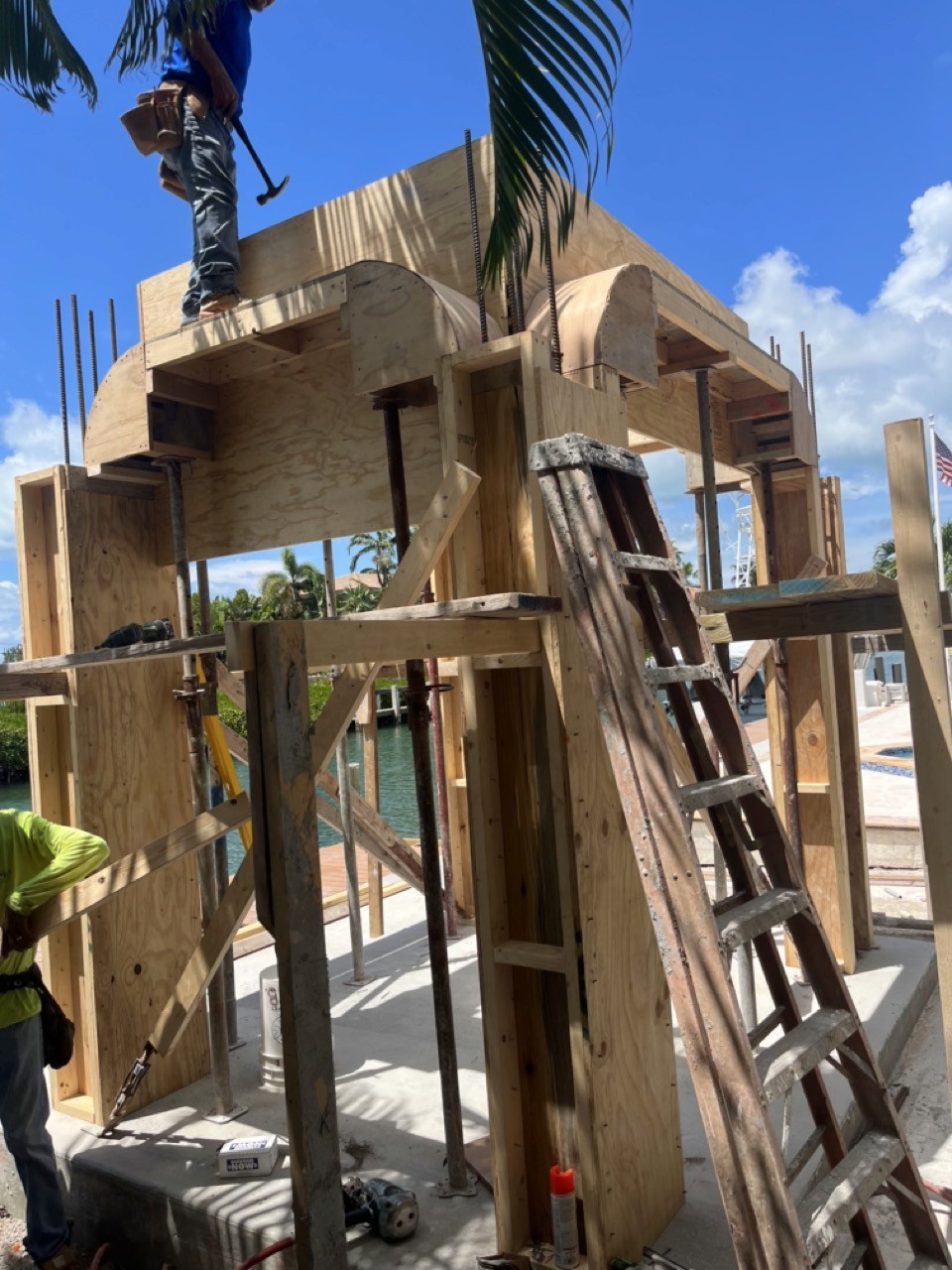 Modern kitchen with a wooden dining table, white chairs, and a hanging light fixture above.