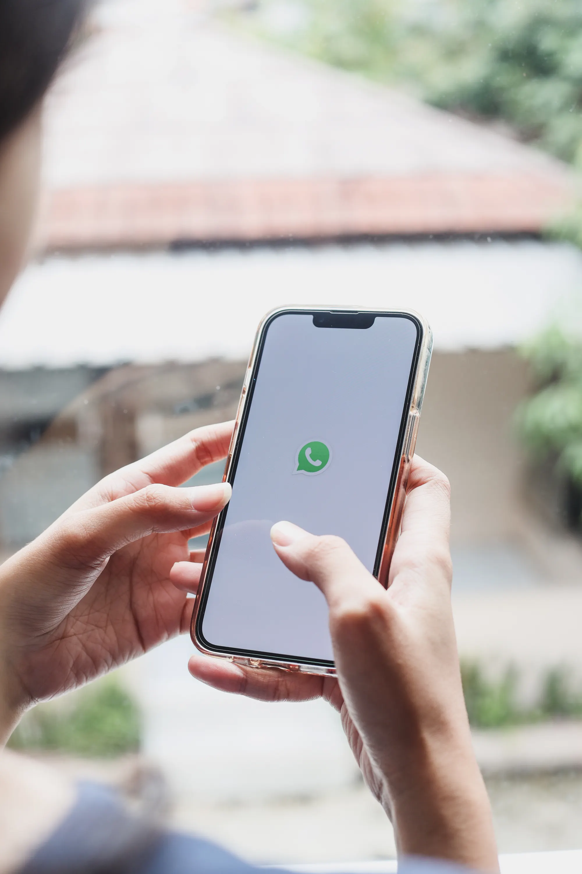 mão segurando smartphone com interface de aplicativo