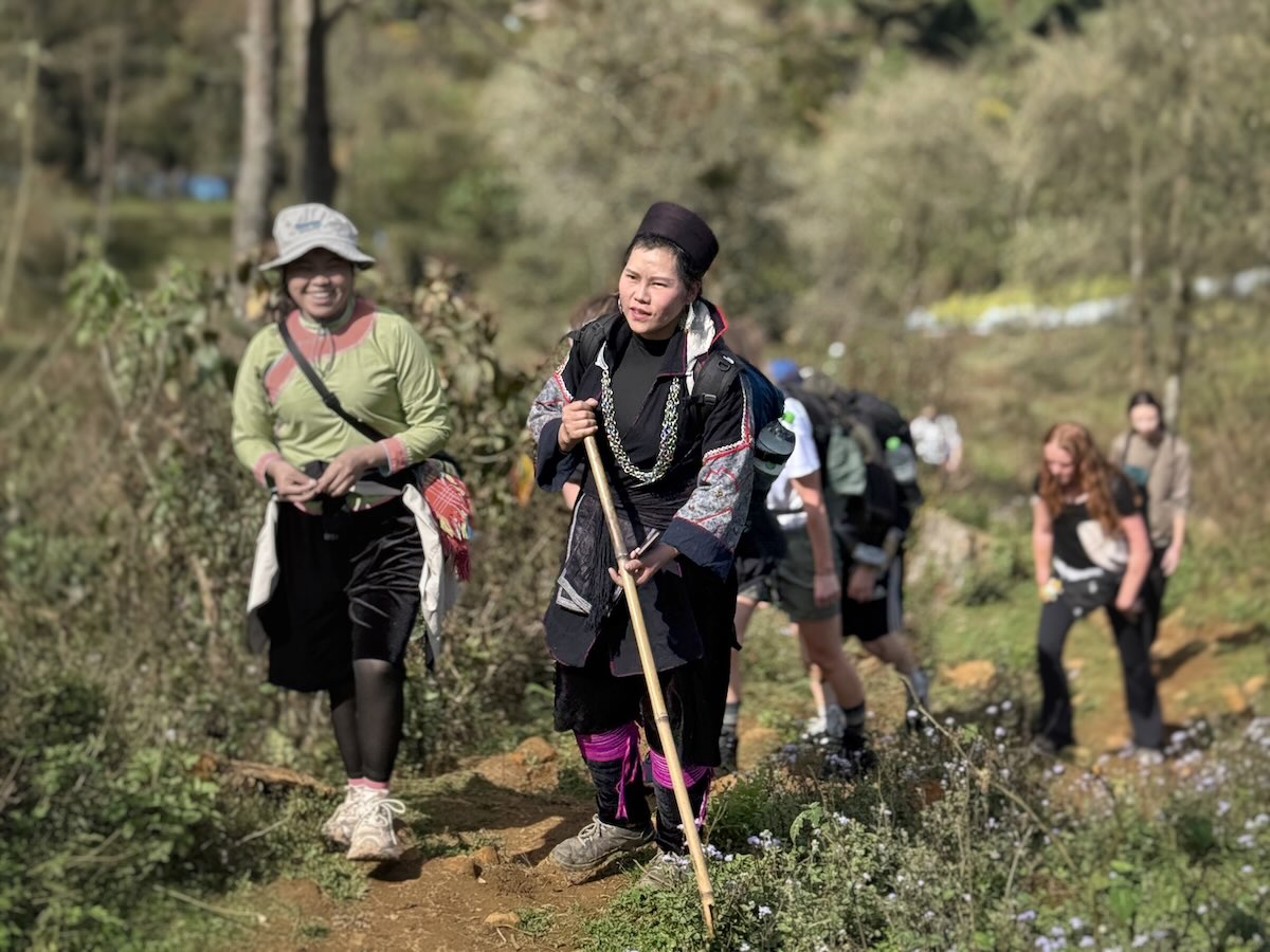 Local Black Hmong guide leading trekkers on the Fansipan route near Sapa