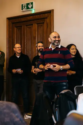 Some people standing together inside a room.