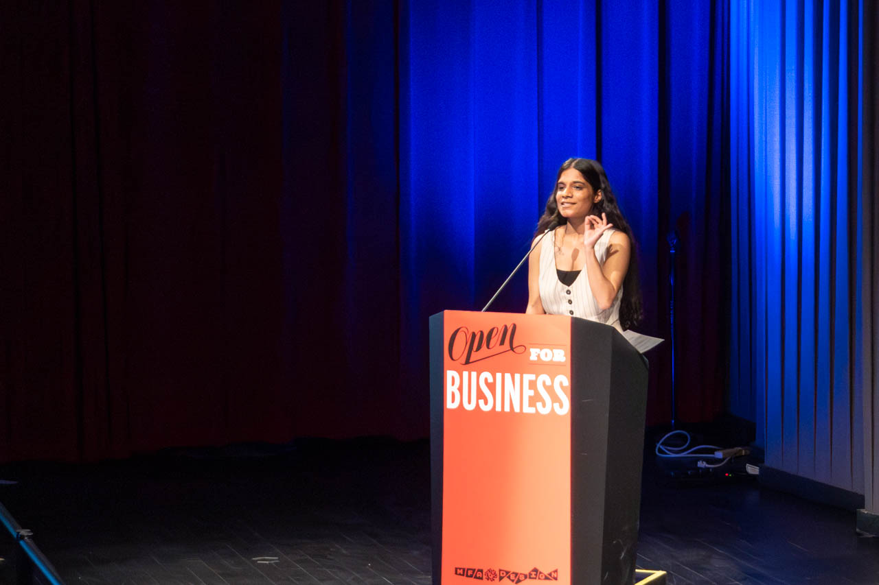 woman standing at a podium delivering a presentation