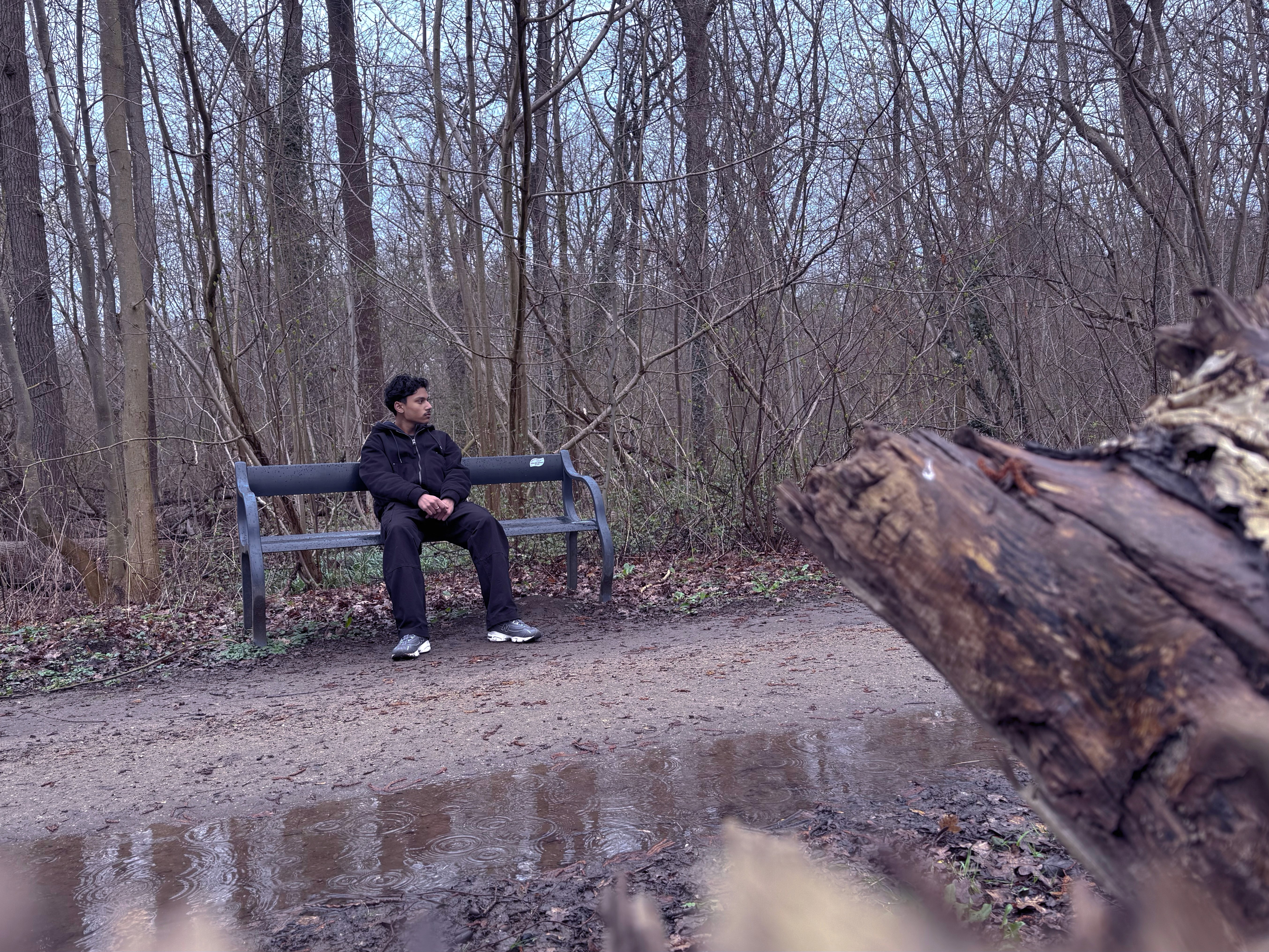Me in the woods sitting on a bench