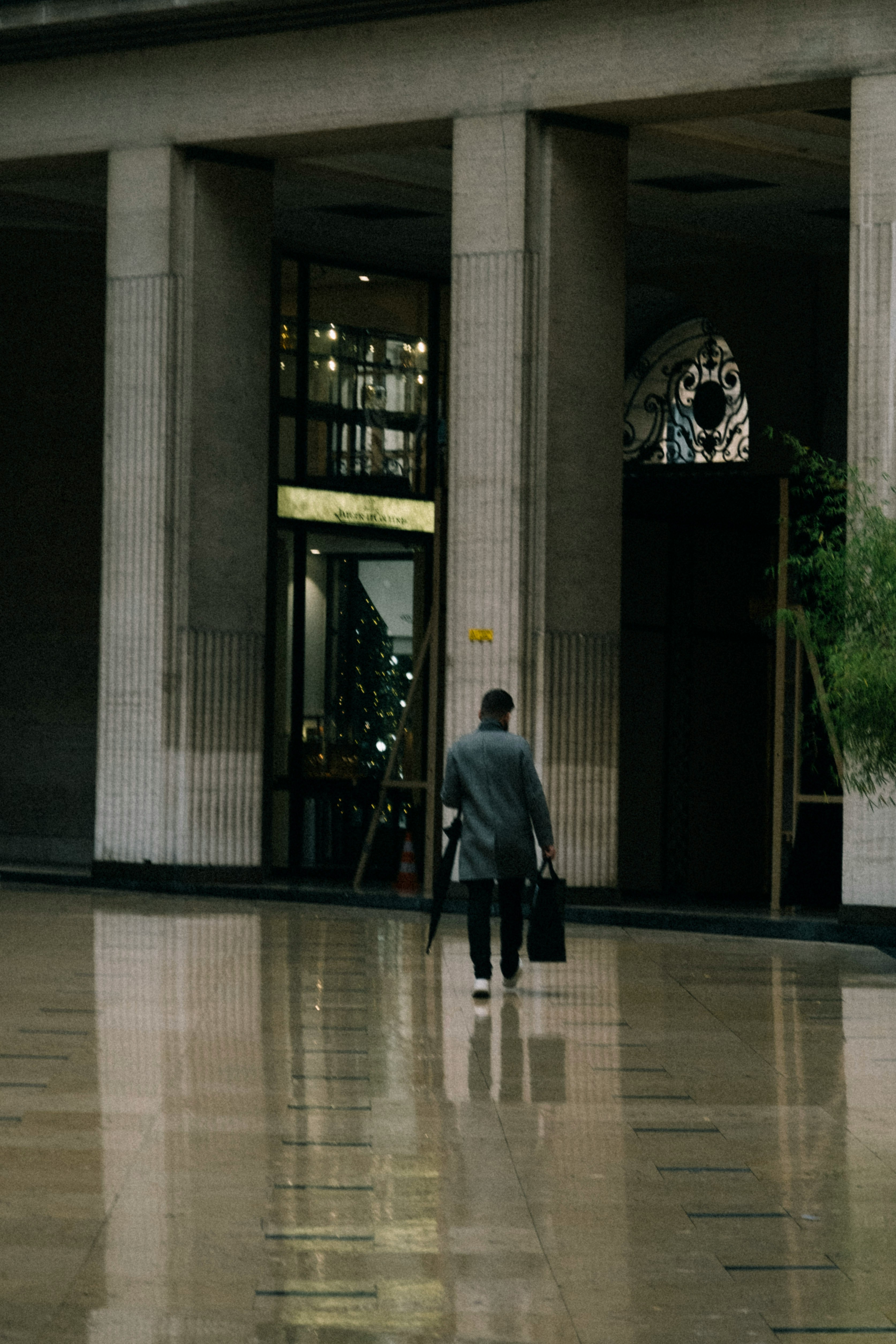 a man walking through a lobby with a suitcase