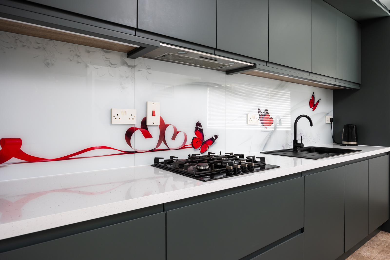 Modern two-story home with large glass windows, warmly lit interiors, and a balcony. Surrounded by trees and a manicured lawn at dusk. Cozy ambiance.