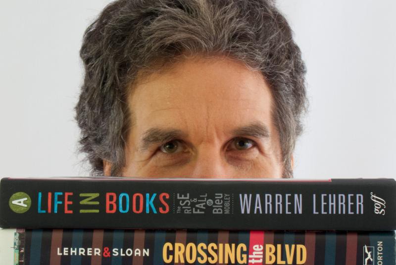 A poster showing a man's half of face and some colorful text that says: A Life in Books. The rise and fall of Bleu Mobly. Warren Lehrer. Lehrer and Sloan Crossing the BLVD.