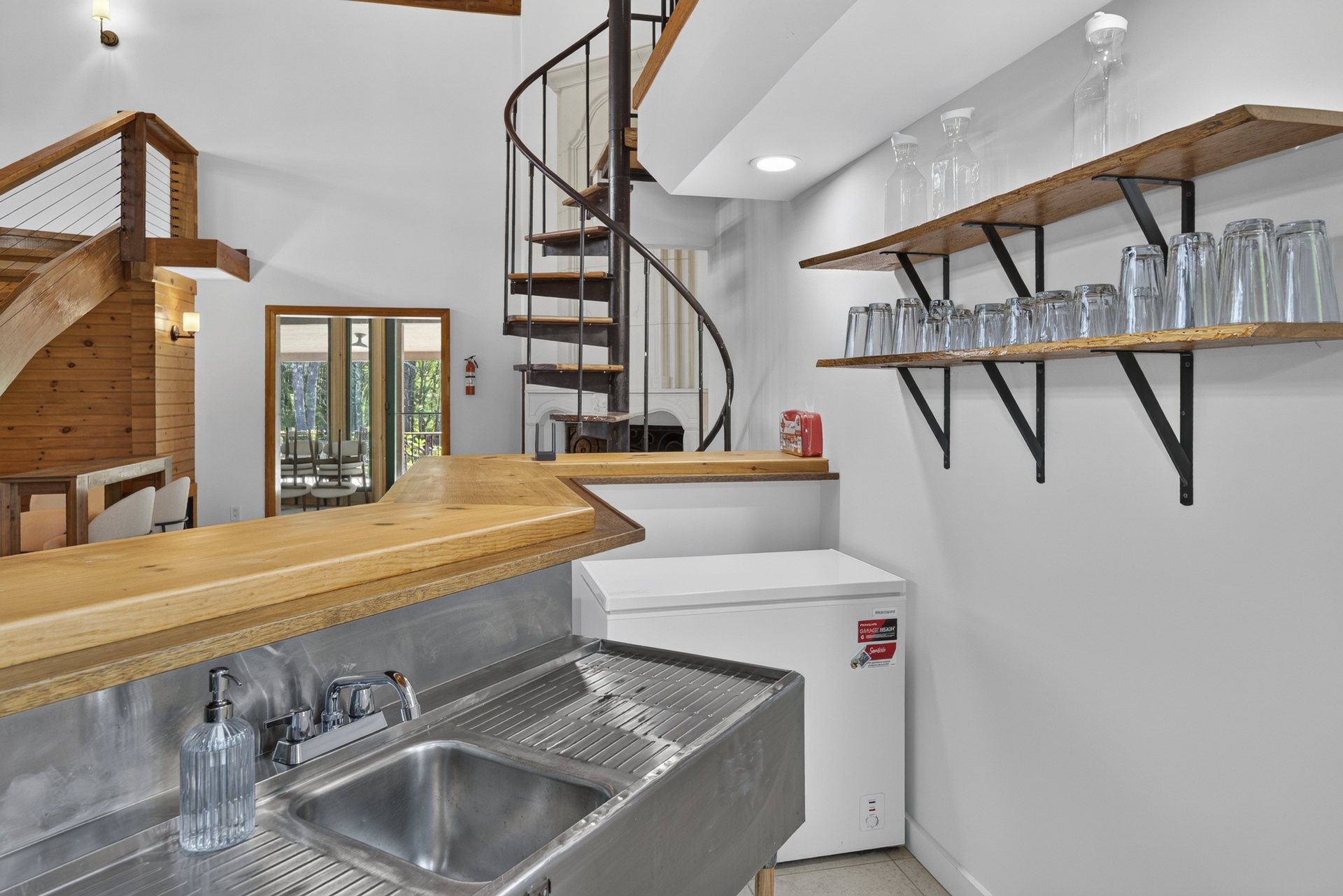 Wet bar with open shelving and a spiral staircase beside it