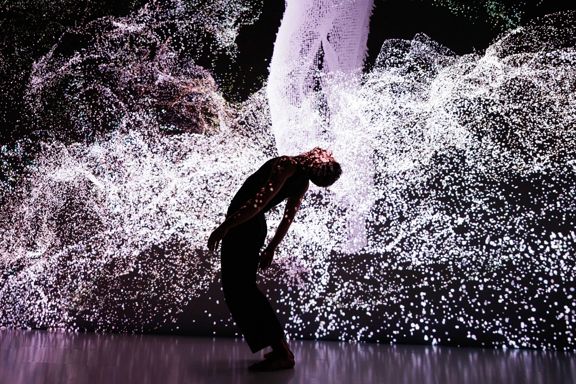 Dancer illuminated by particle projections