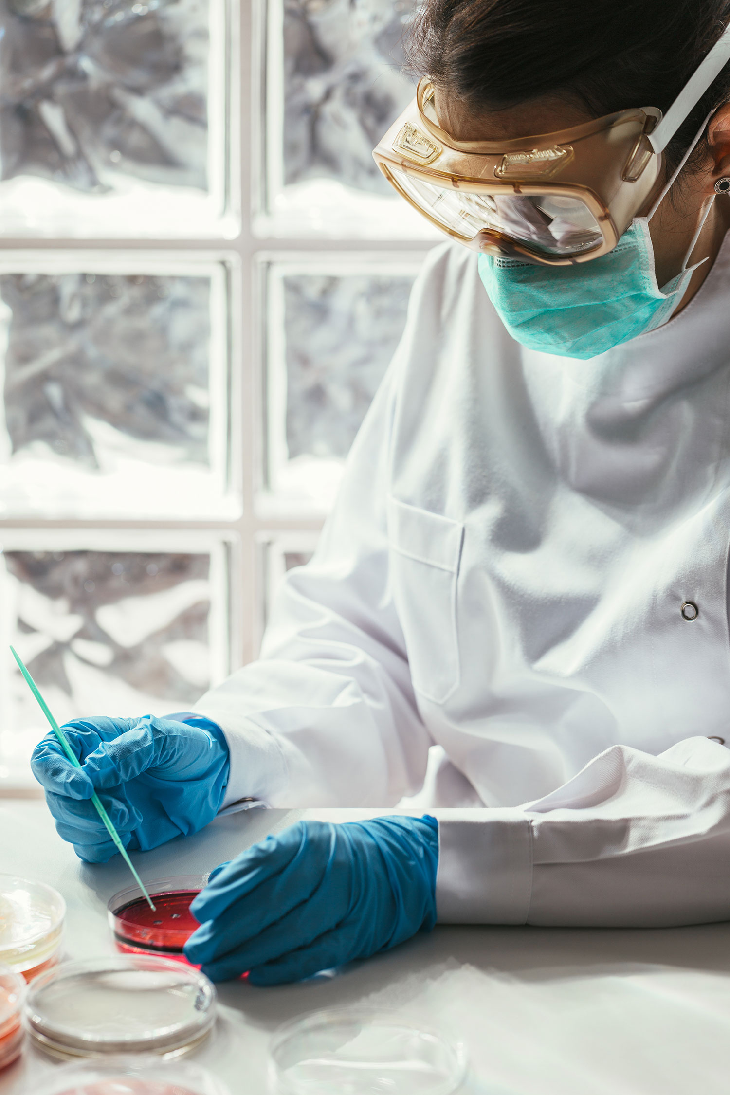 A woman with red hair and a black sleeveless top smiling confidently in a bright, modern indoor setting.