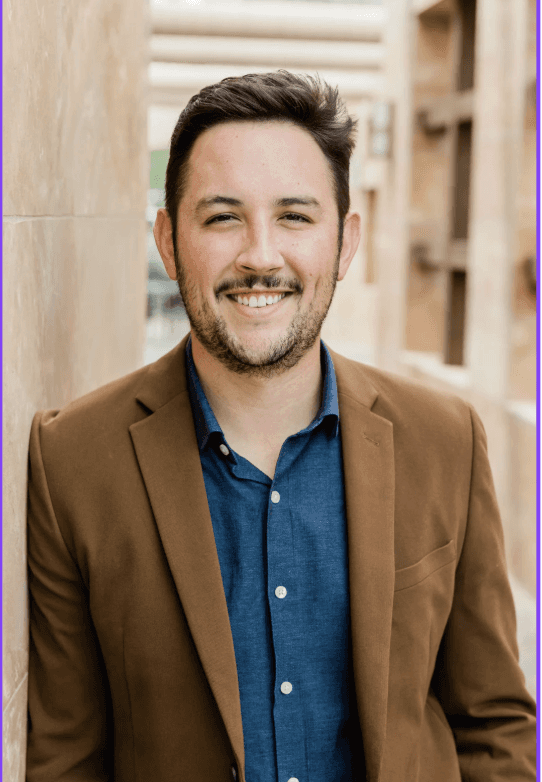 a man with a goatee smiles at the camera