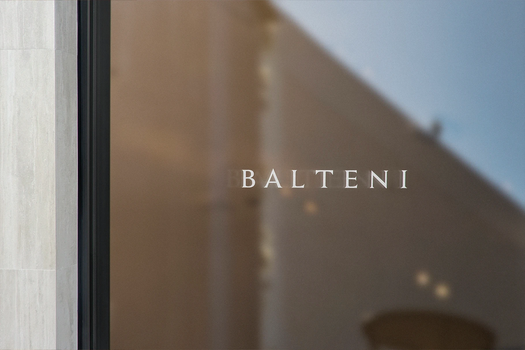 Luxury storefront window mockup with a white sans-serif logo for a modern brand.