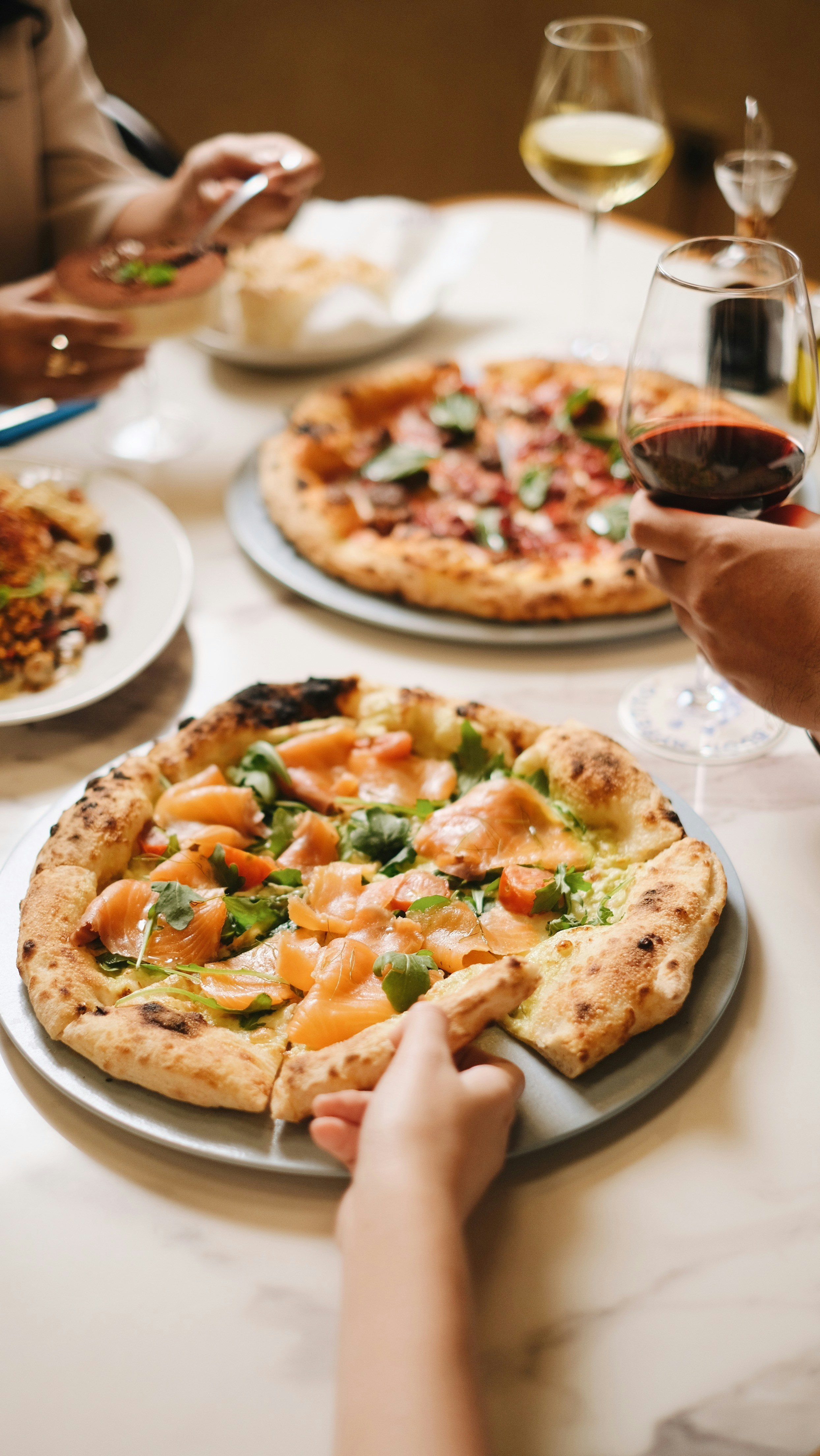 A group of people sitting around a table eating pizza
