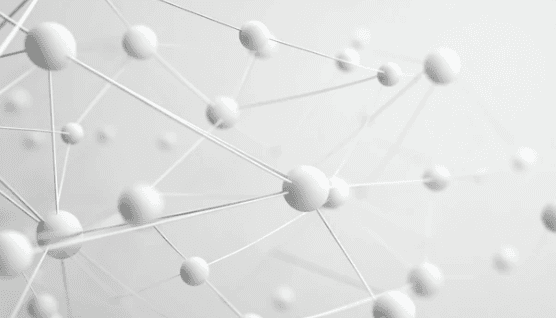 Two men discuss a project while standing at a laptop in an office.