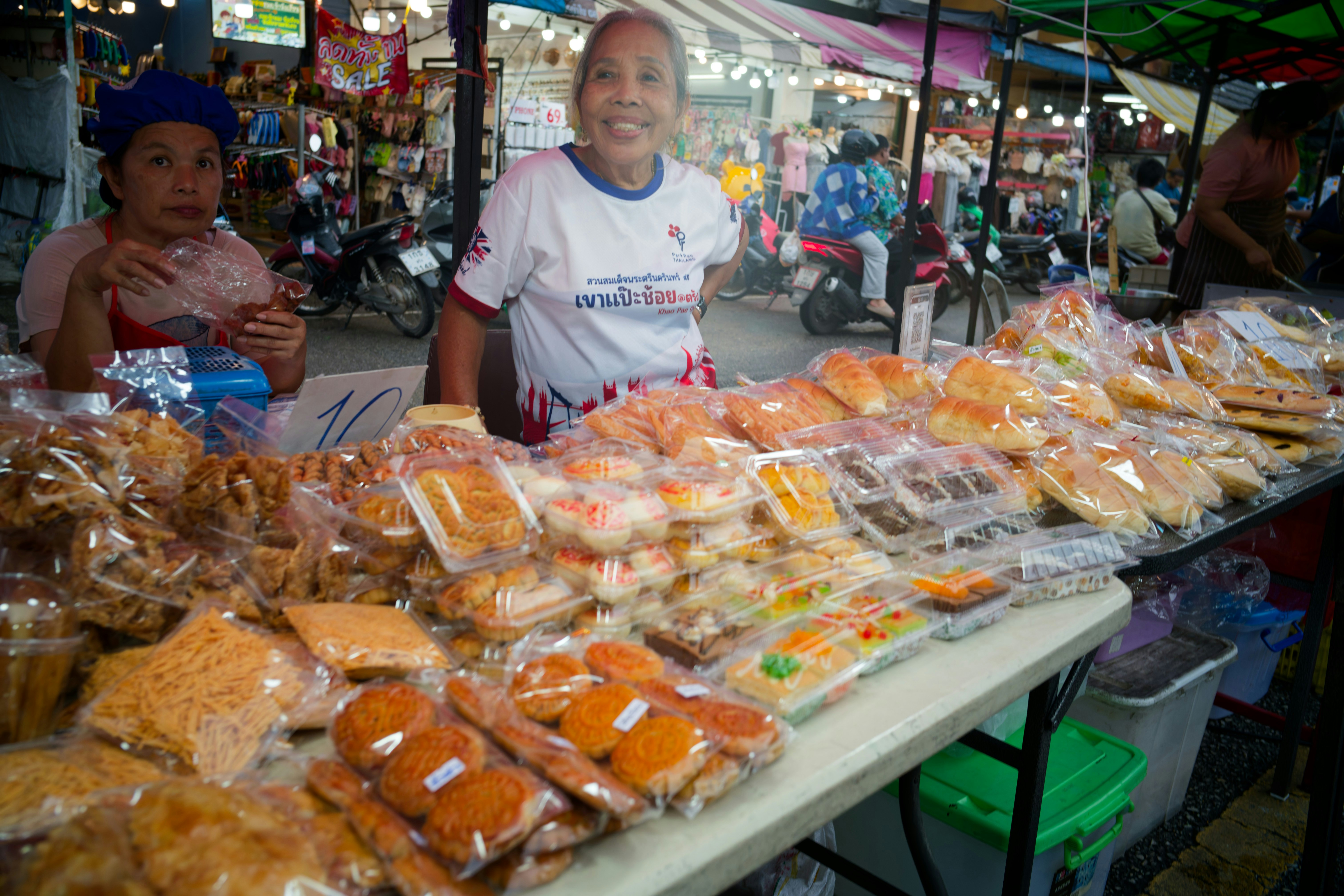 Vendors selling baked goods at an outdoor market.