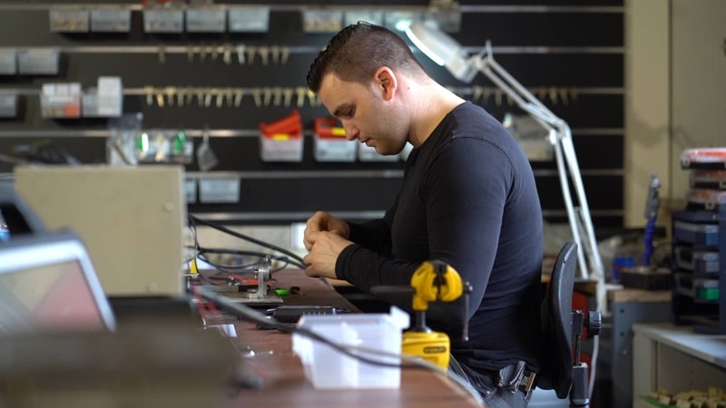 Specialist aan het werk aan een sleutel in de werkplaats van De Sleutelspecialist