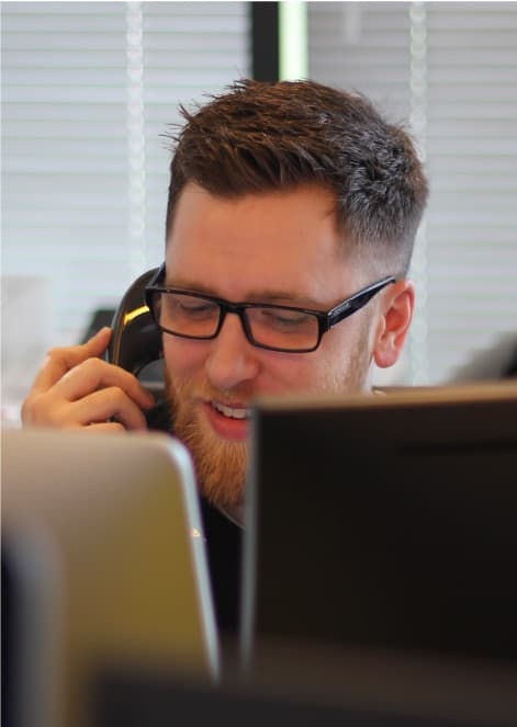 An IT support expert man on the phone helping a customer.