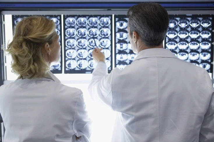 Doctors carefully looking at CT scans of Patient