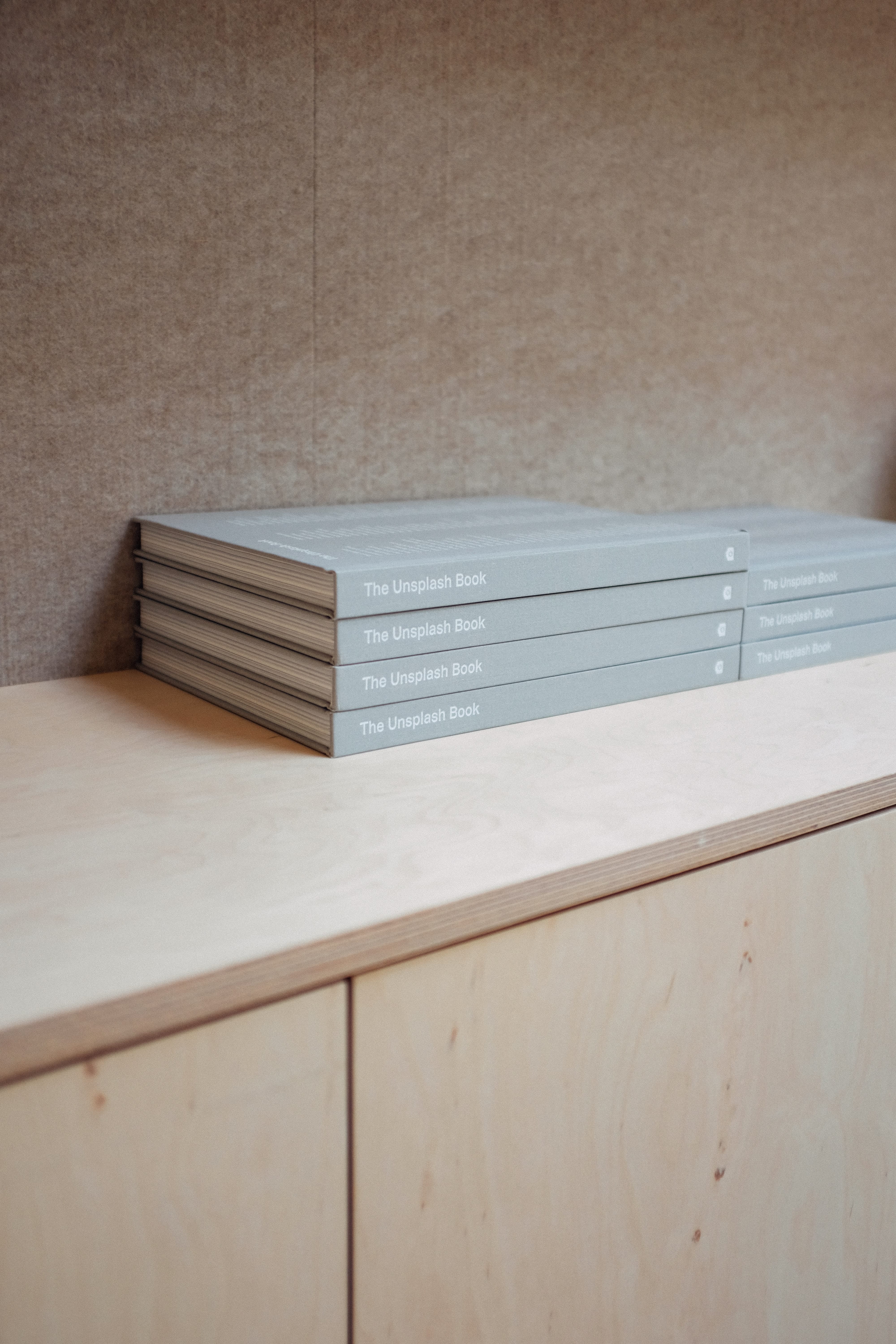 Neutral color books on wooden shelf