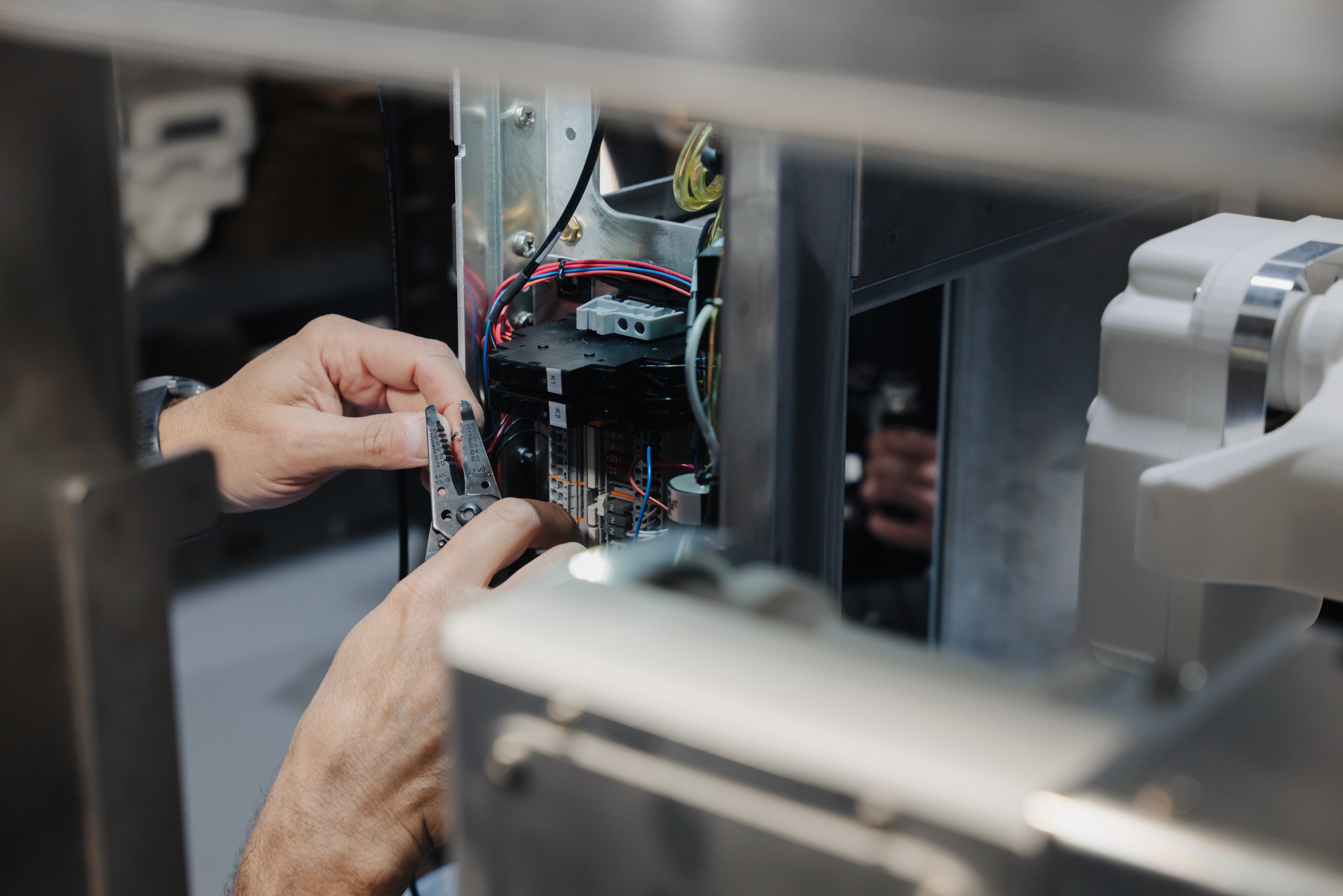 Backside of a person with a had and curly hairs sits in front of a screen in a room