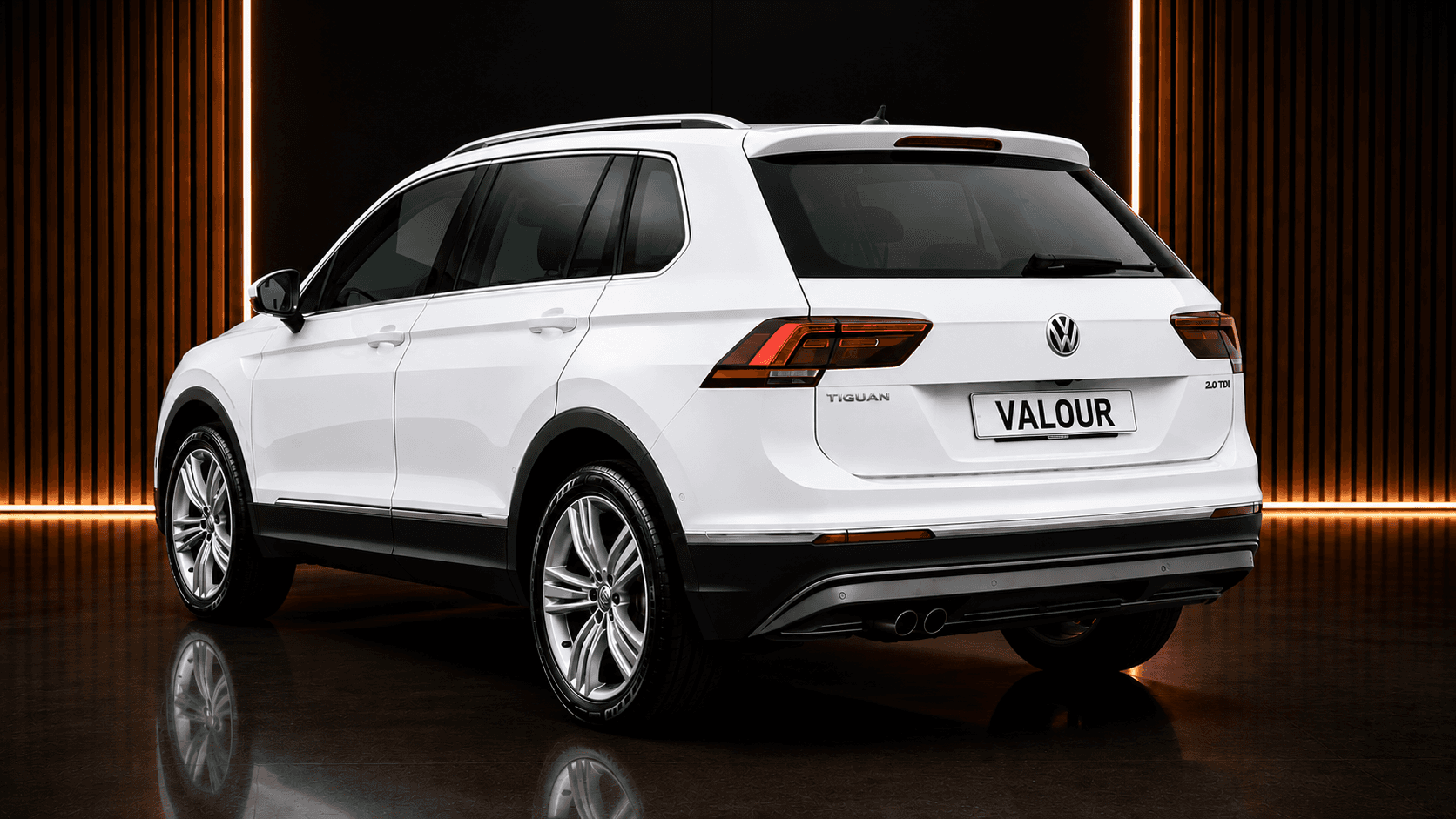 A sleek, gray luxury SUV with bronze alloy wheels is parked on a wet concrete surface under a cloudy sky, showcasing its modern design and aerodynamic contours.