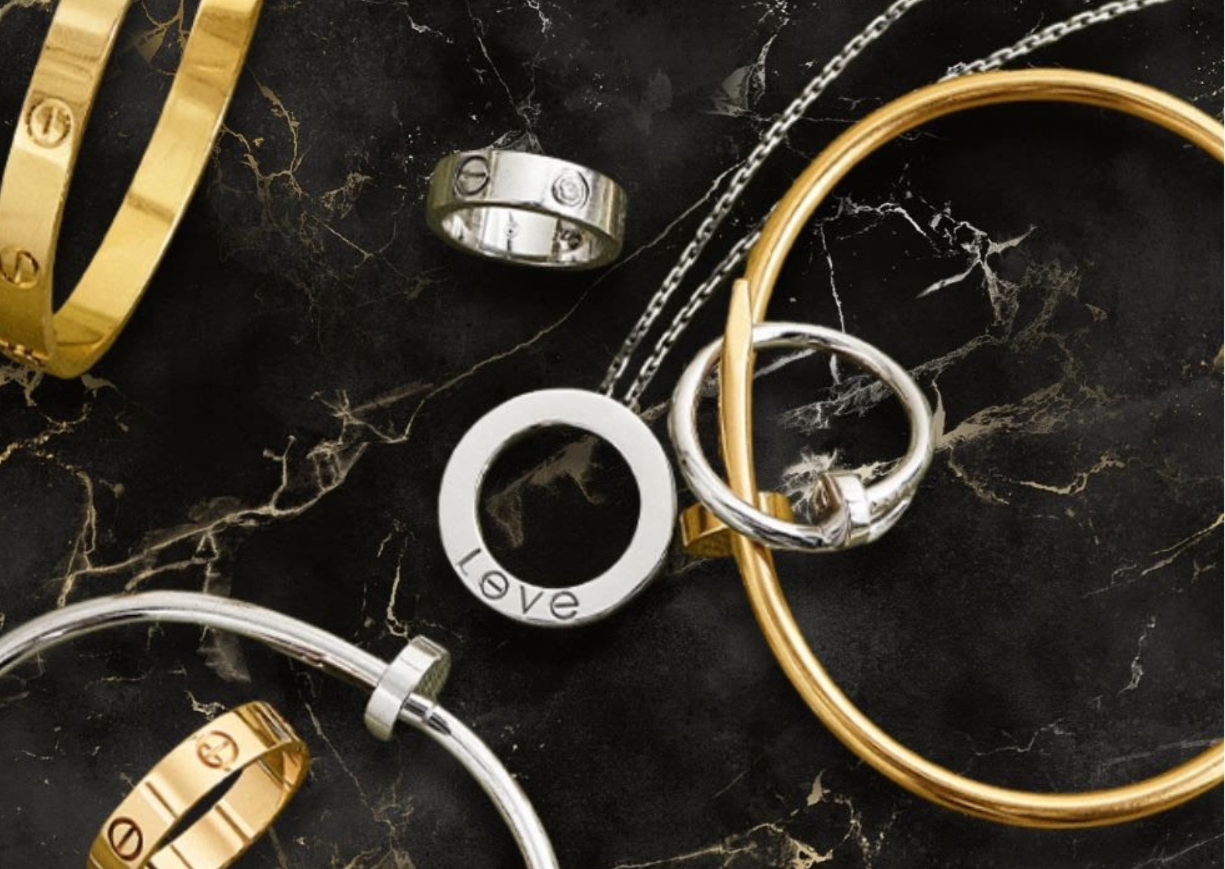 Collection of Cartier luxury, elegant, stylish, classy, sophisticated jewellery in gold, silver, white gold, rose gold and diamonds from collections Love, Juste un Clou and Panthere, against a black and gold marble table exuding luxury and expensive and high end.. 