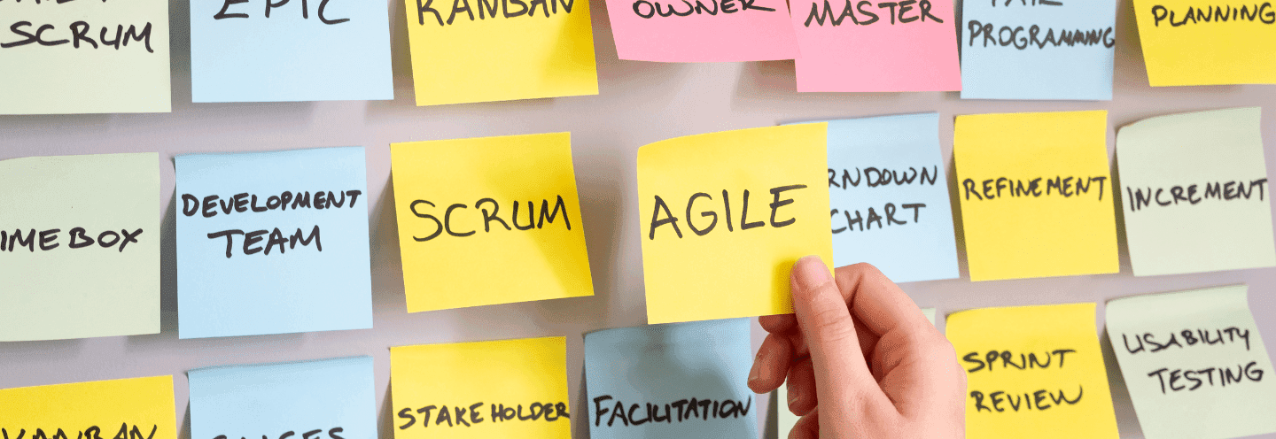 Agile Development featuring a yellow sticky note "AGILE" on a wall with other notes, key Agile concepts: Scrum, Kanban and others 