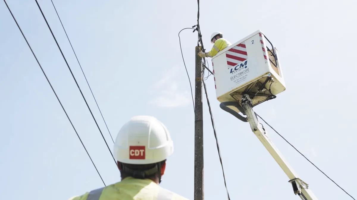 Ouvrier électricien en hauteur sur nacelle maintenance réseau électrique aérien