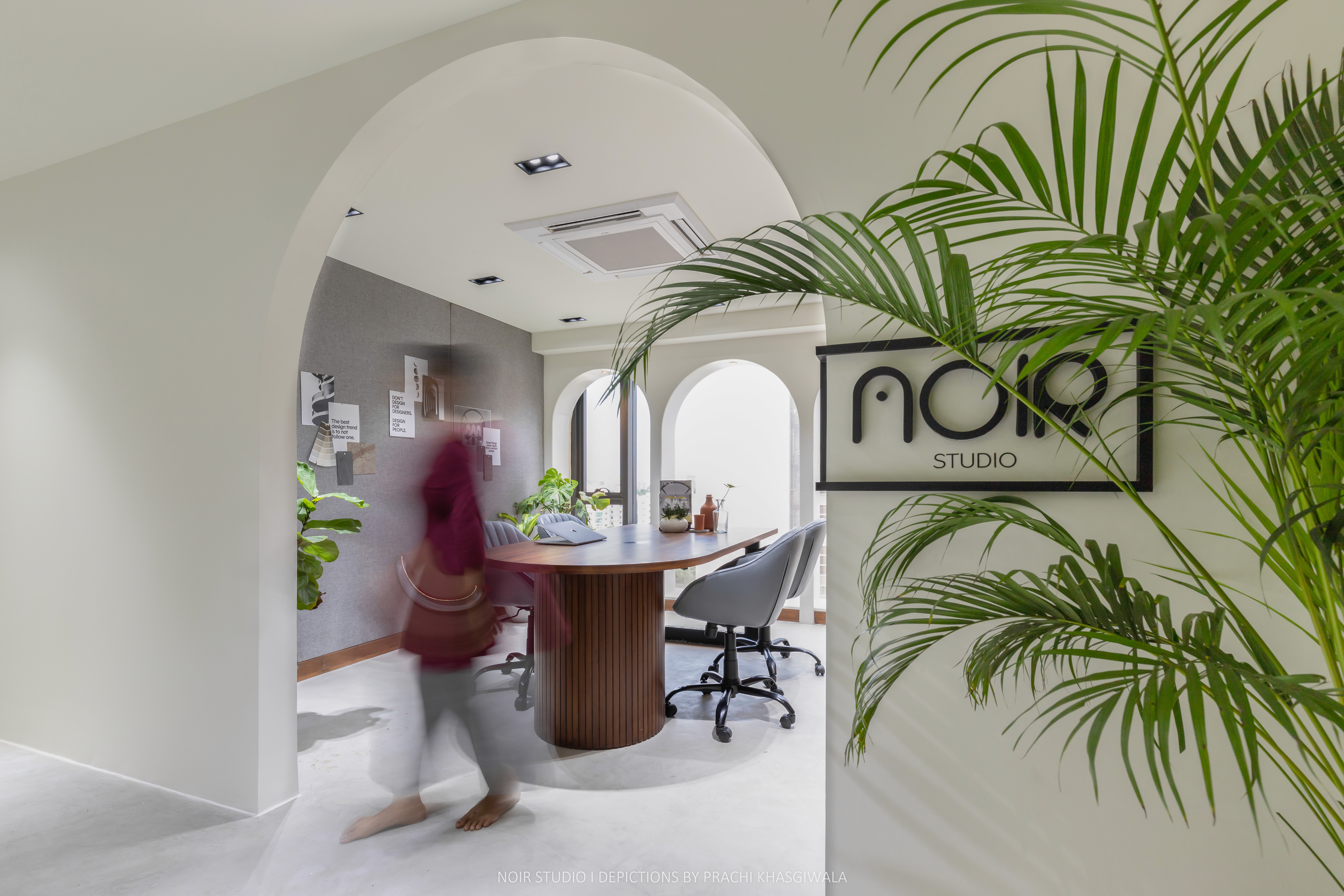 Black and white image of people working at a table with laptops, showing hands gesturing during discussion of digital content displayed on screens, with fabrica® logo in the corner.