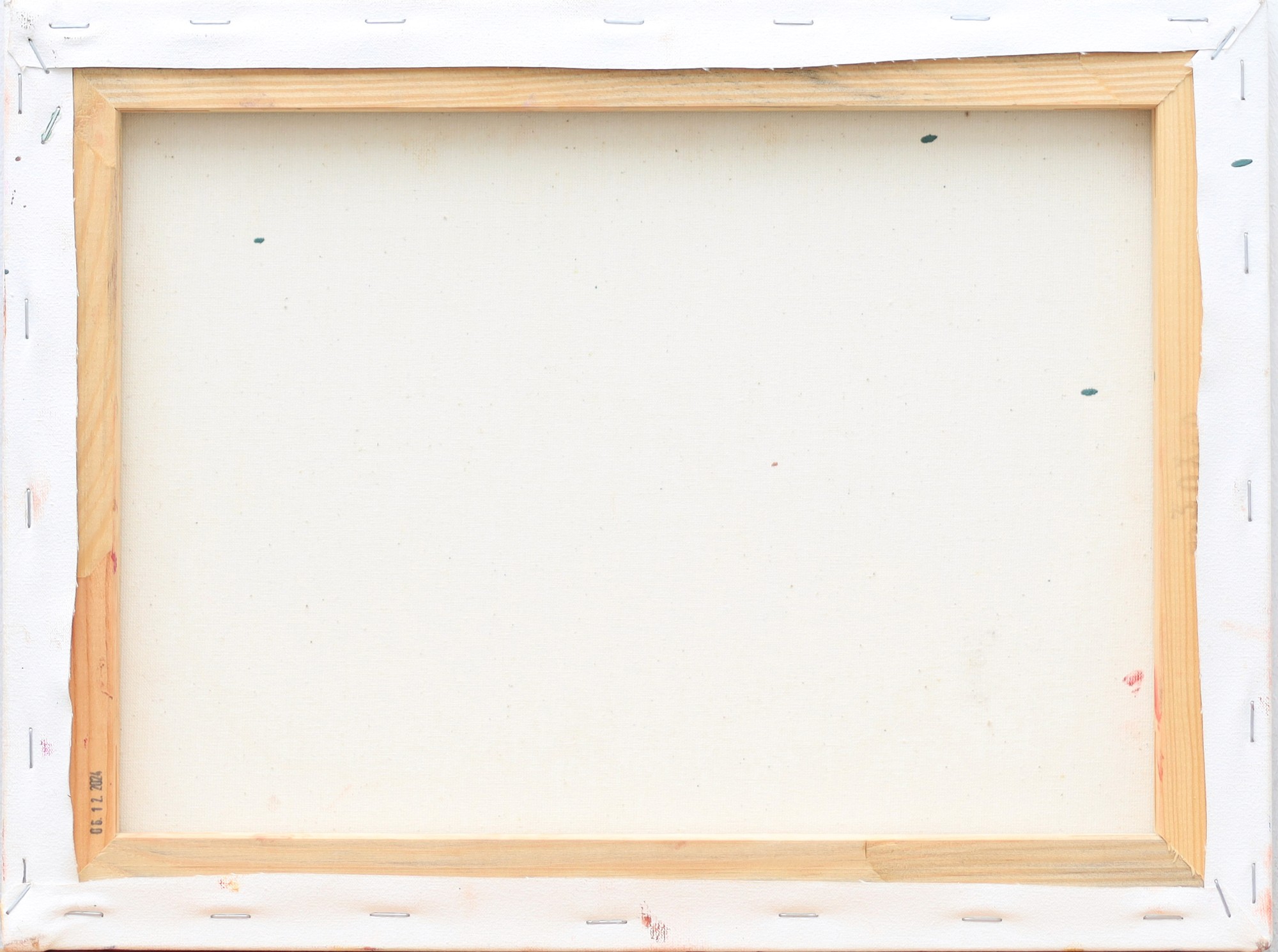 An empty wooden canvas frame with visible staples and a blank white canvas ready for painting.