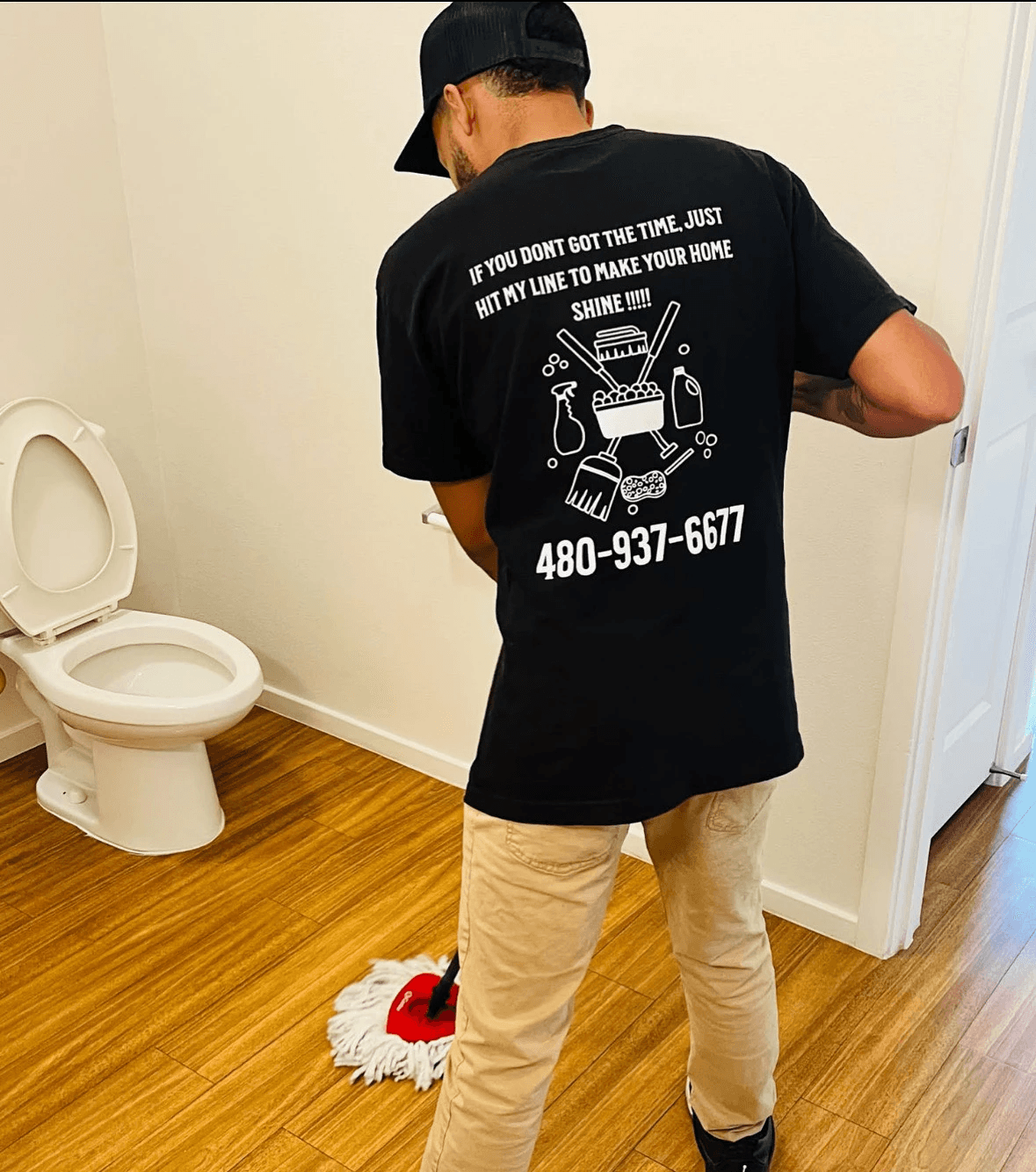Team member mopping a floor in a clean organized restroom.