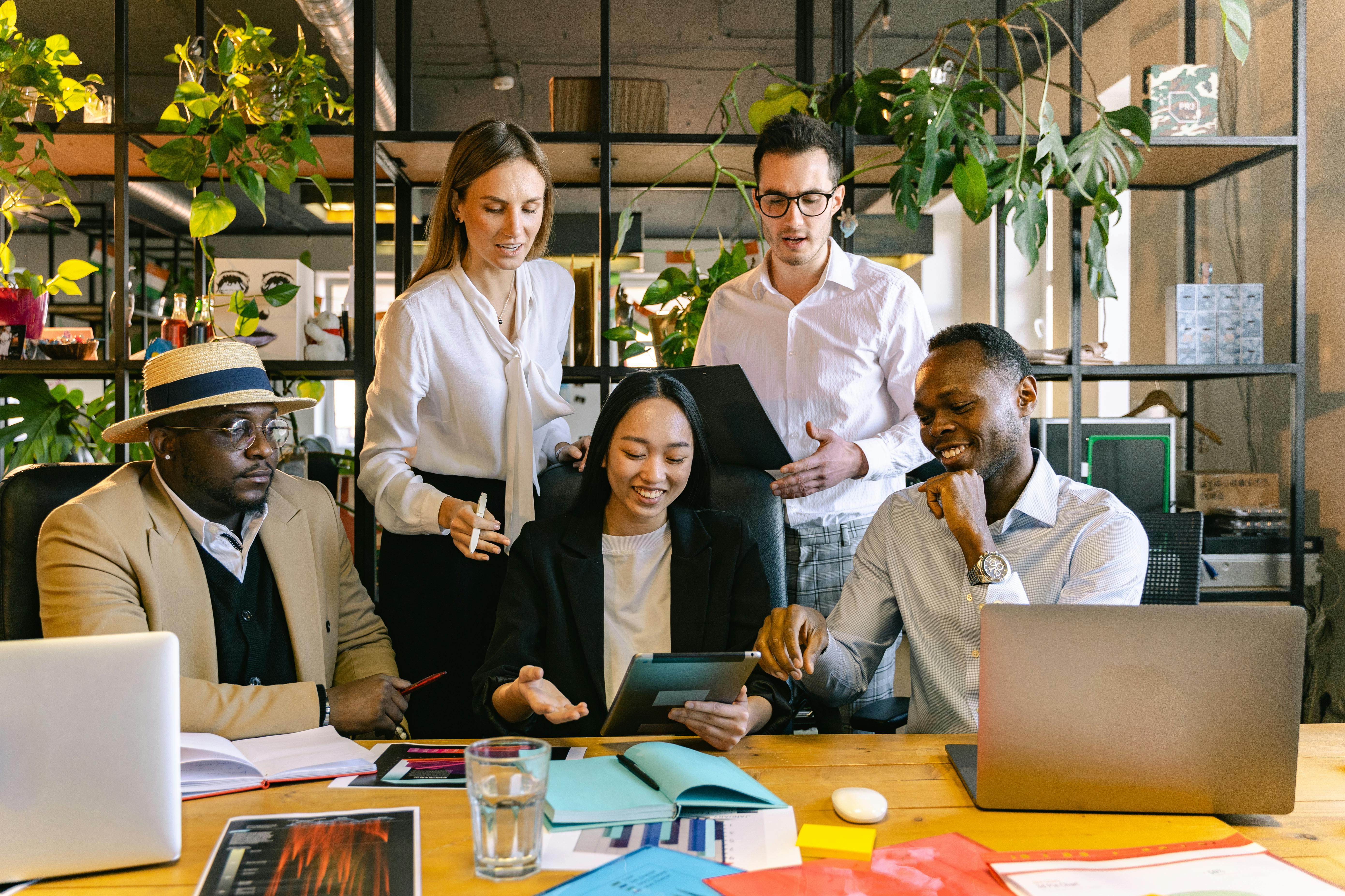 A diverse team of professionals collaborating on a business strategy at a modern office within the Abu Dhabi Global Market district.