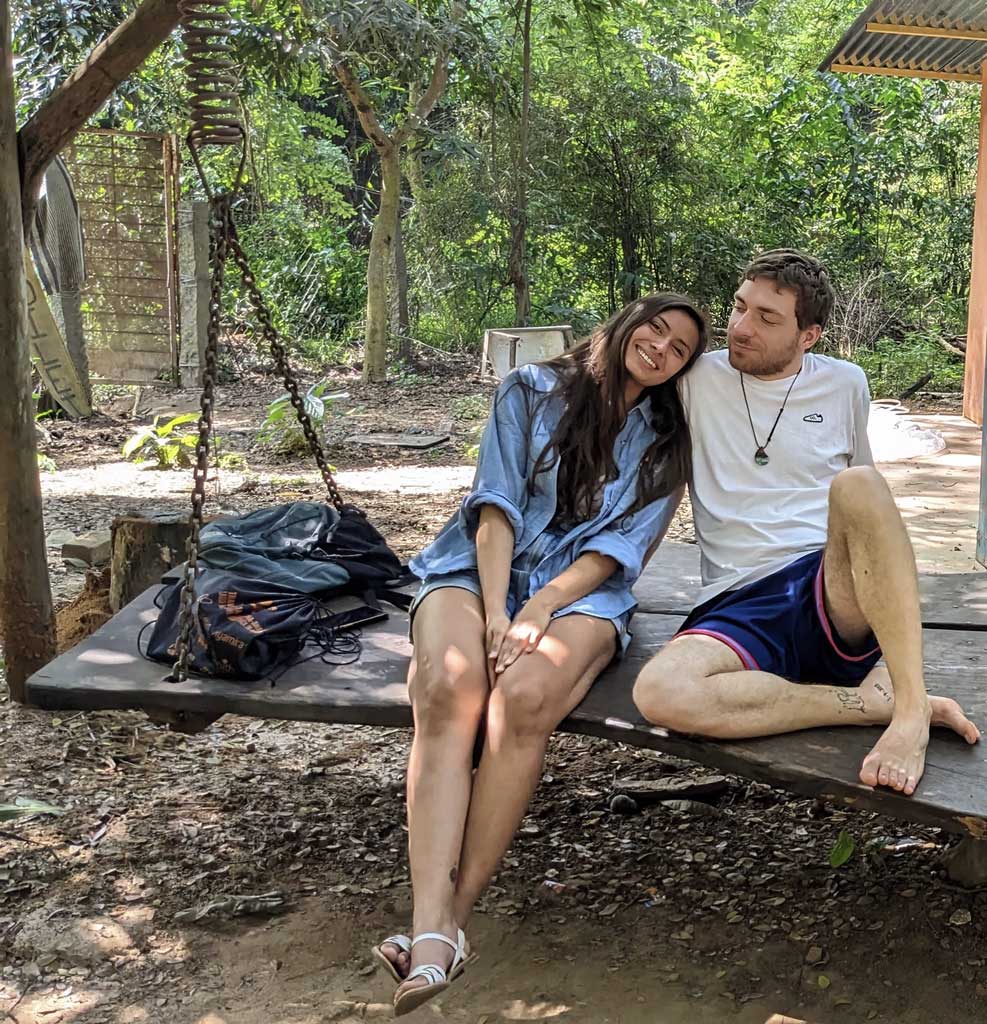 Image of Pit and Gabriela next to each other, smiling on a swing