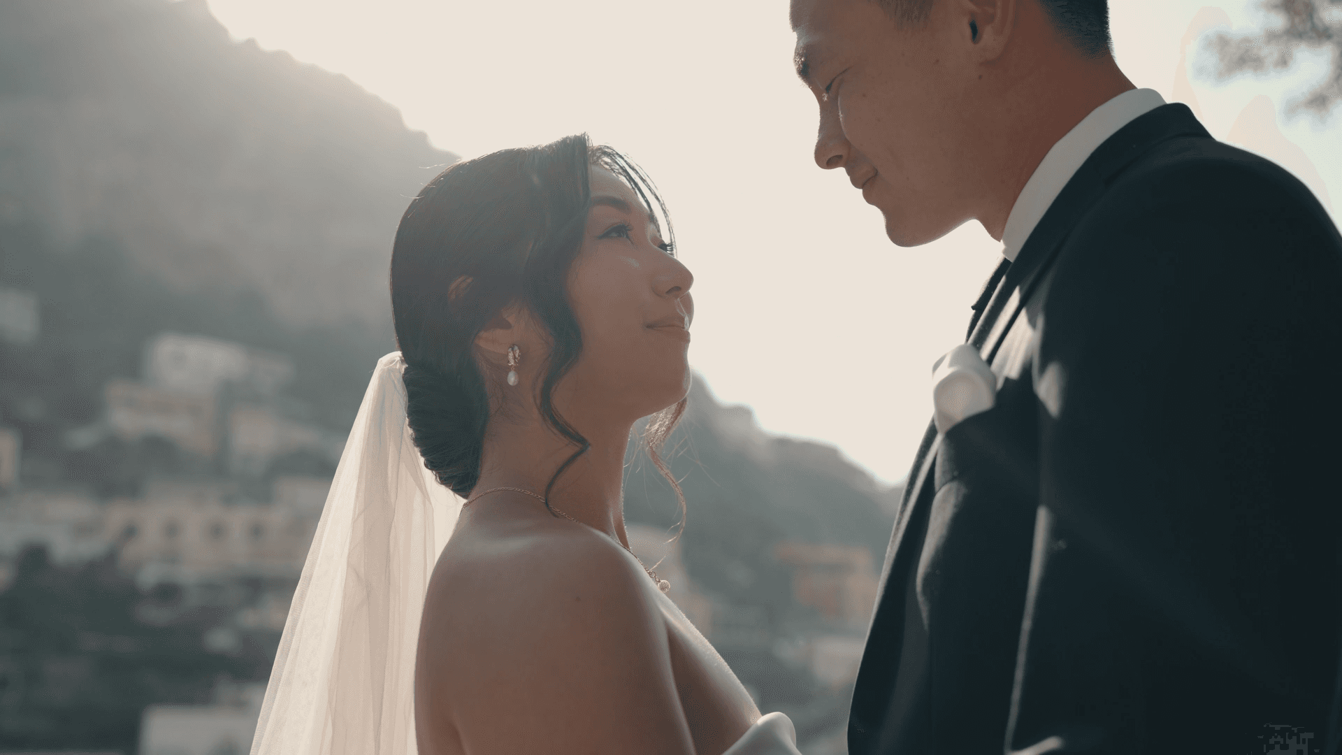 A person with short, red hair wears a tan coat and a white turtleneck, gazing confidently. The background is a neutral gray, creating a calm, professional tone.