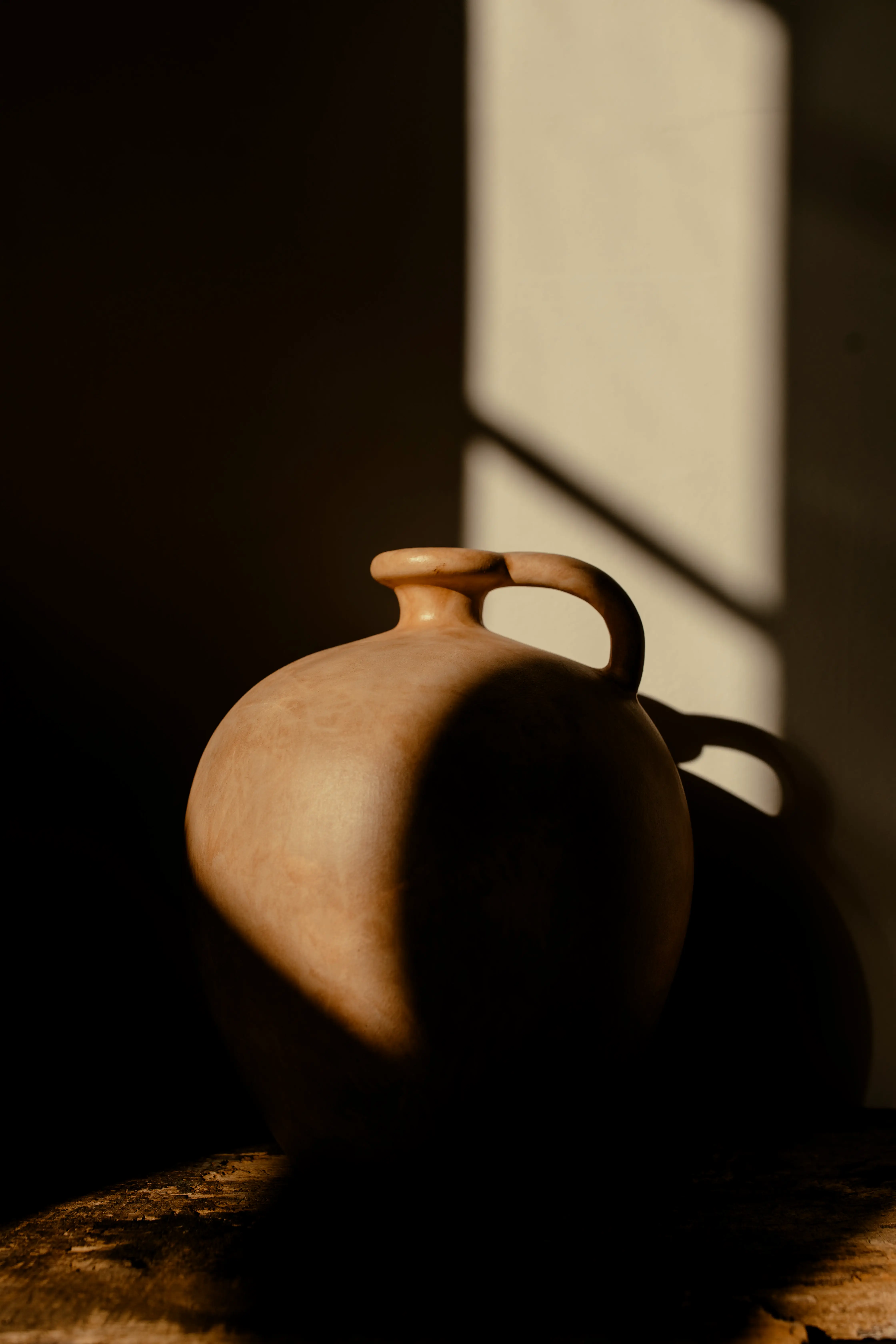 A round ceramic vase with afternoon light casted onto it