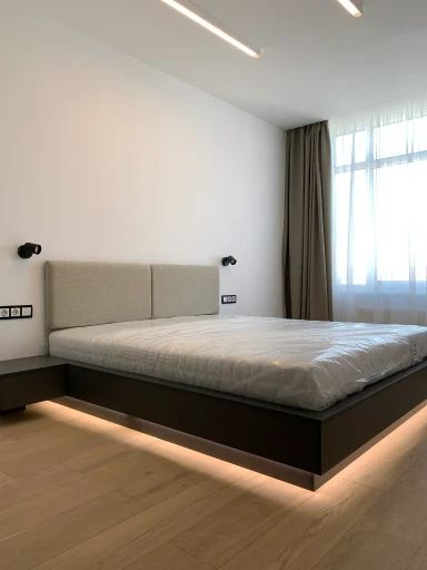 Комплексне меблювання спальні в сучасному стилі. Вбудована шафа, м’яке узголів’я ліжка з декоративними стіновими панелями та інтегрованою LED-підсвіткою. Виготовлення меблів для спальні на замовлення в Києві.