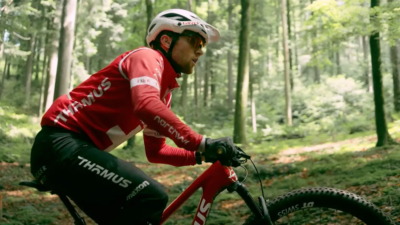 Guy mountainbiking through the forest