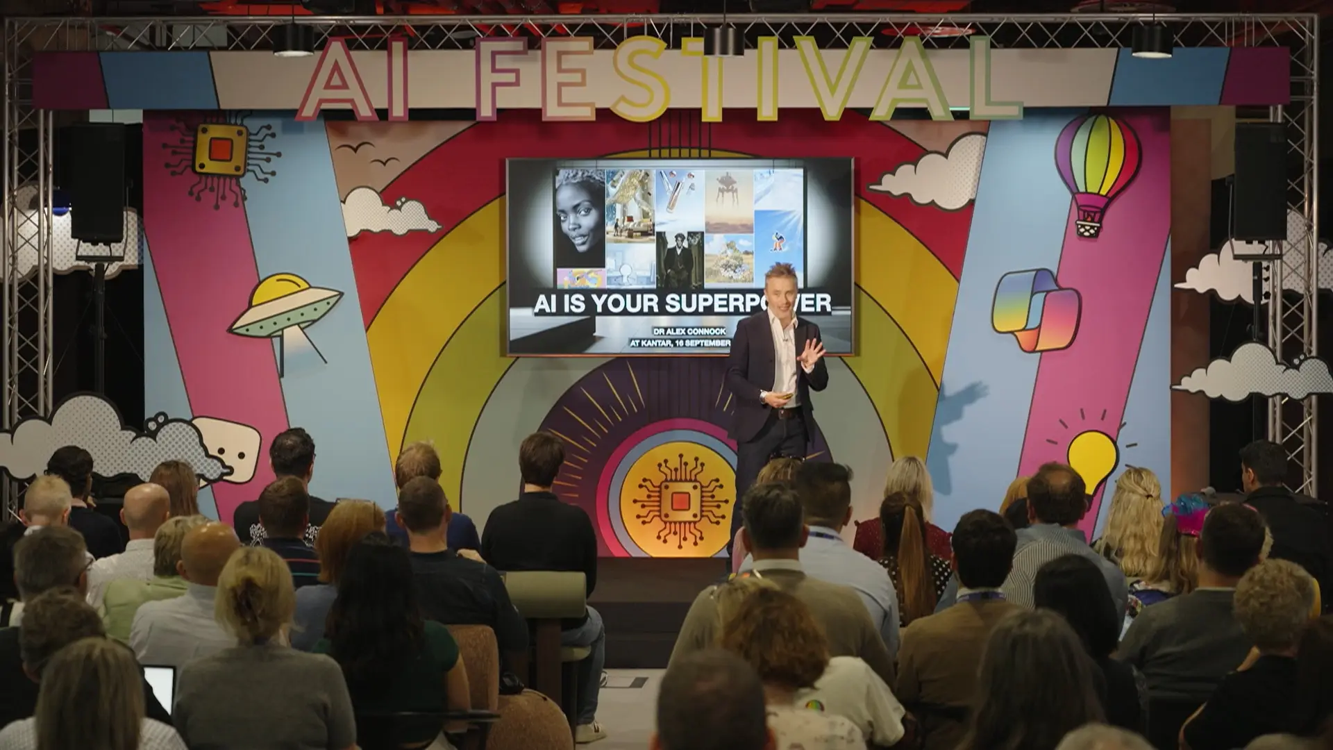 Panel discussion in progress at the Kantar AI Festival, with speakers seated on stage and audience watching.