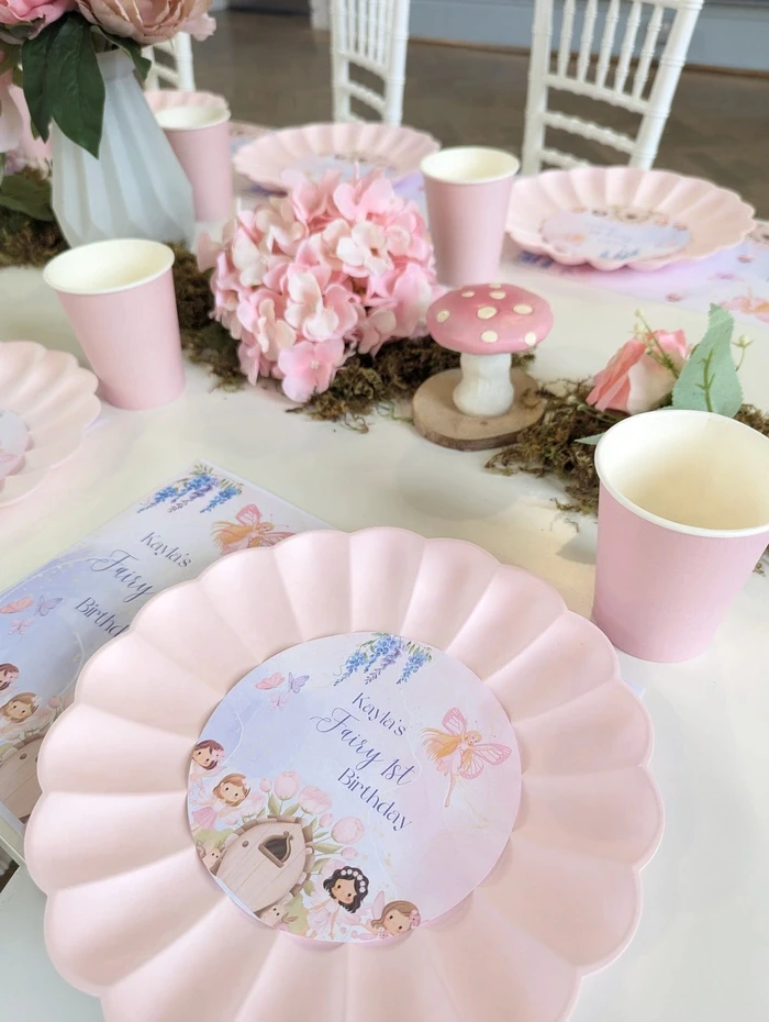 Pink pastel table styling with personalised plates, mushroom decor and party cup