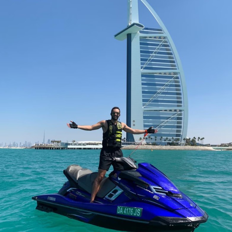 Man posing on a Yamaha waverunner jet ski with the Burj al Arab view behind him.