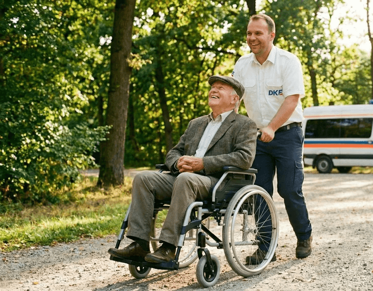 Hero Image - Krankenfahrer schiebt alten Mann in Rollstuhl beide lachen