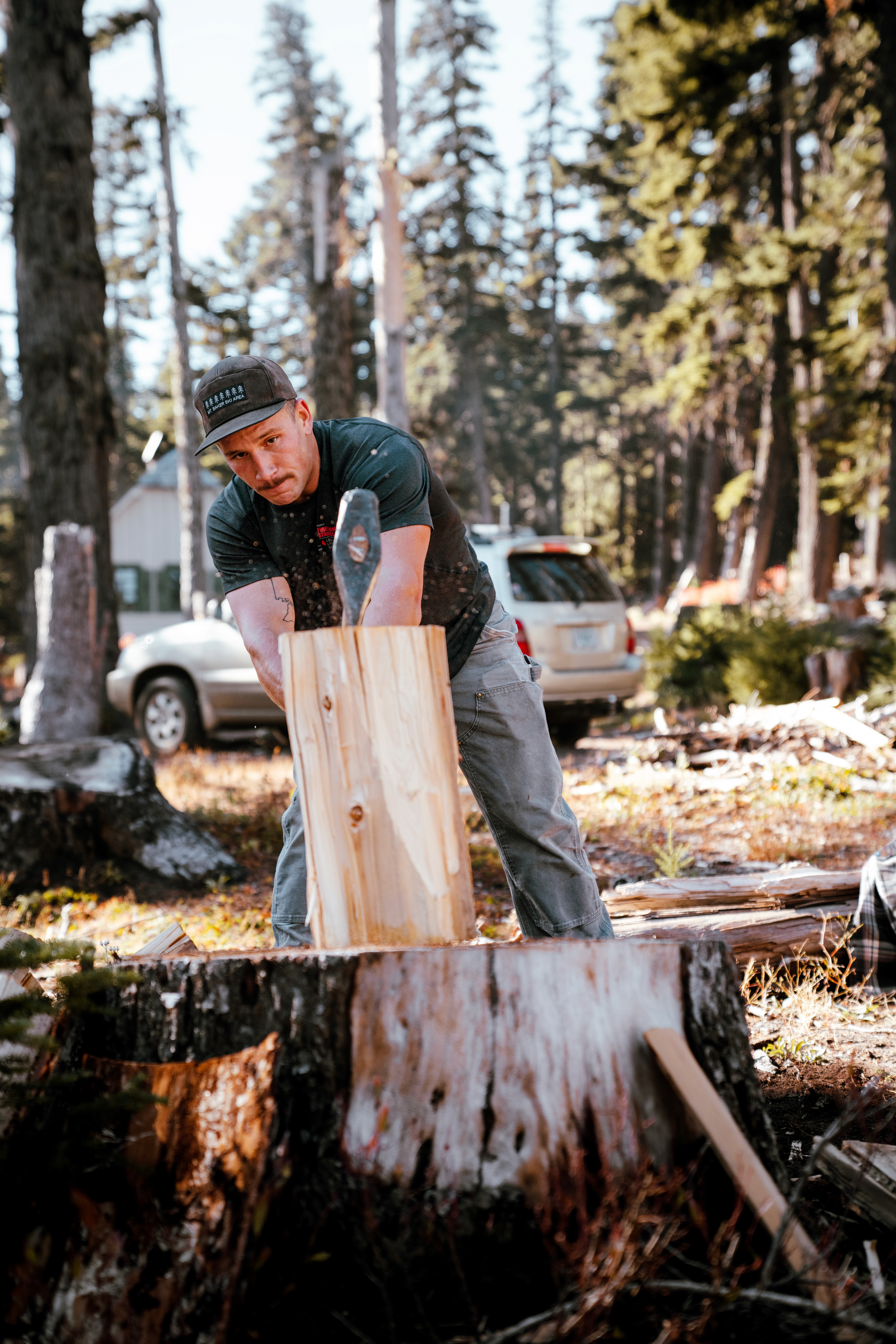 Volunteer splitting firewood to restock cabins for the winter