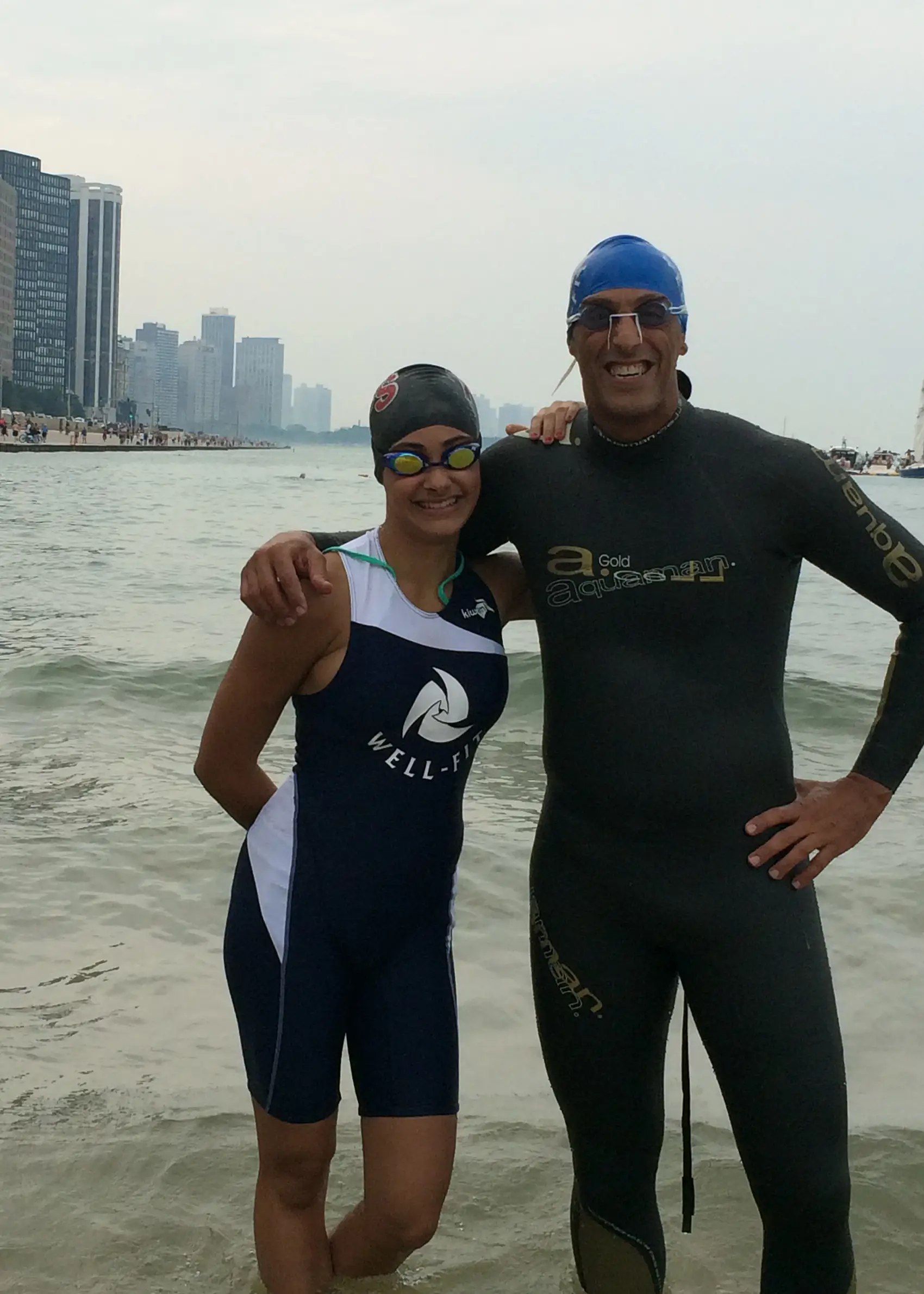 Sharone Aharon and a Well-Fit athlete in wetsuits on the shore of Lake Michigan after a Chicago open water swim training session