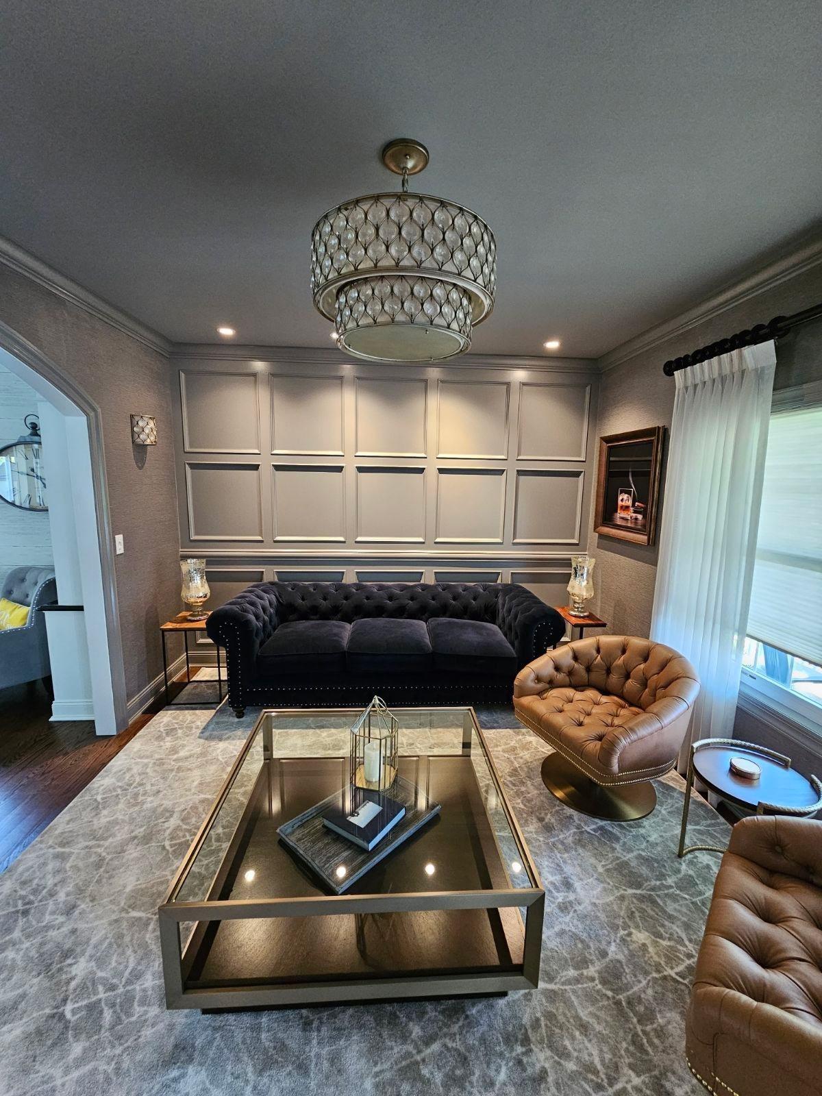 Living room with custom wall paneling and coffered ceiling
