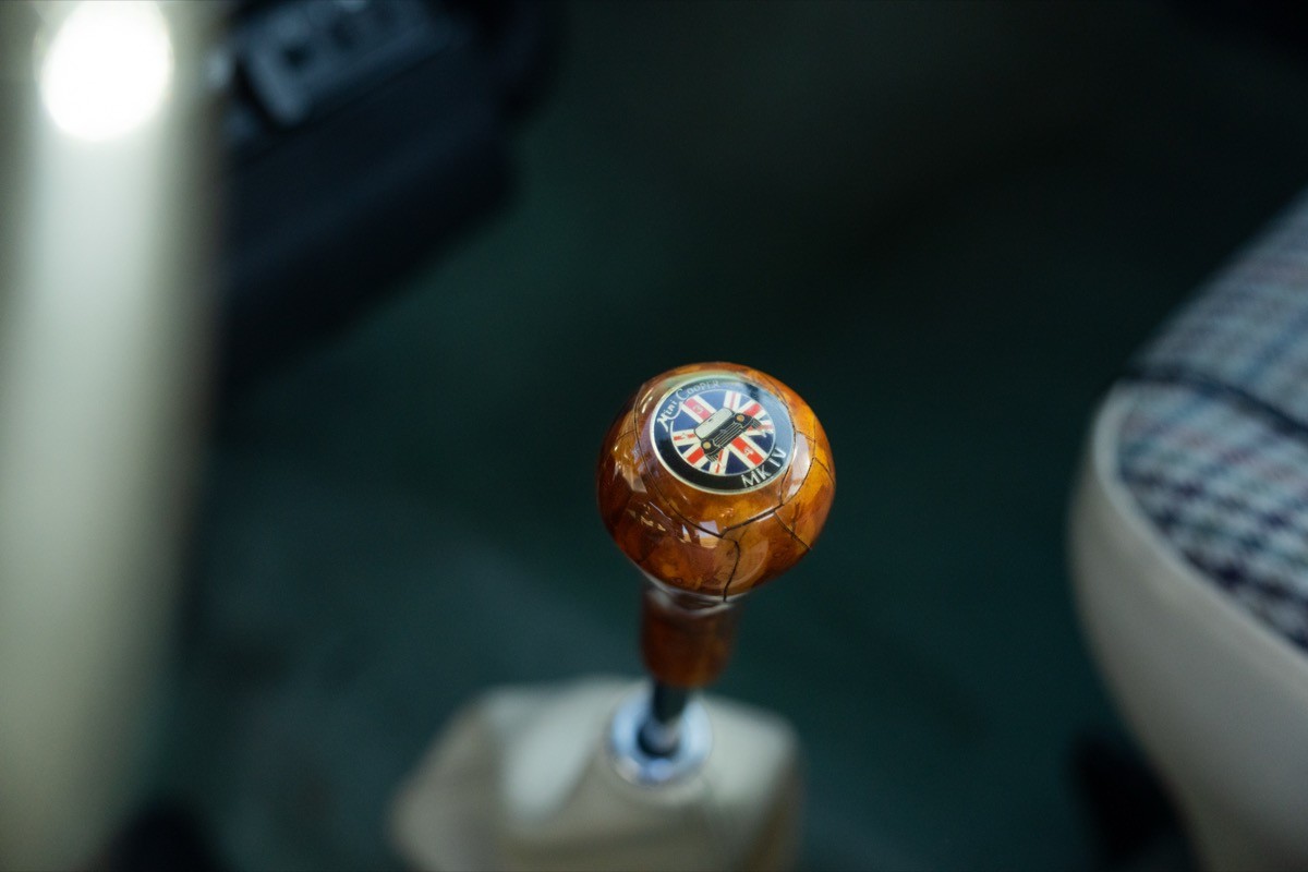 Close-up of a gear shift knob in a vehicle, with a blurred background of car interior.