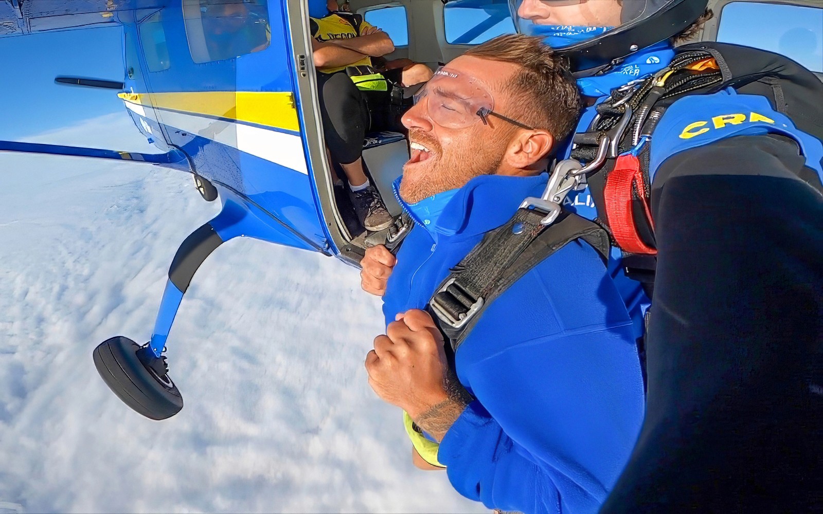 Paracadutismo in tandem sopra Newcastle Beach, Sydney, con una vista dalla porta dell’aereo.