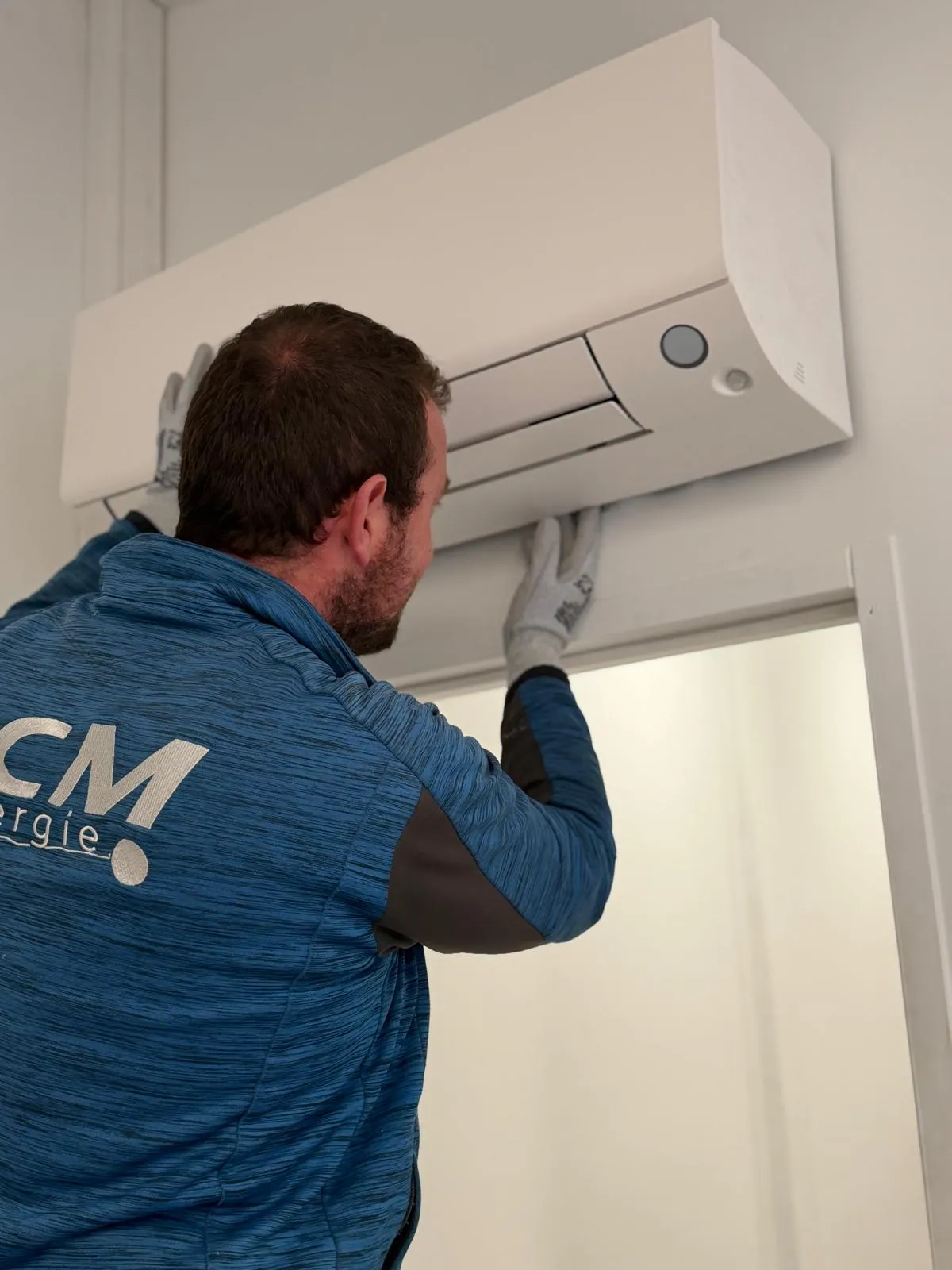 Technicien installant une unité intérieure de climatisation murale split system
